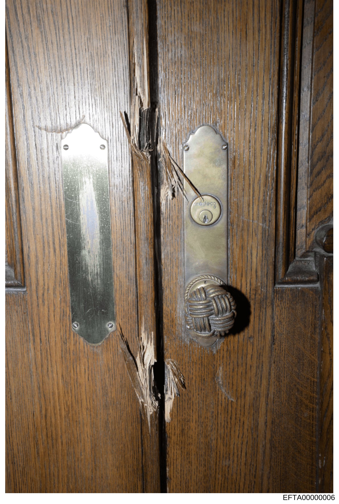 This photograph documents ornate wooden double doors with decorative brass hardware, including door plates and a keyed lock mechanism. The image appears to be evidence documentation from a property associated with the investigation, showing architect