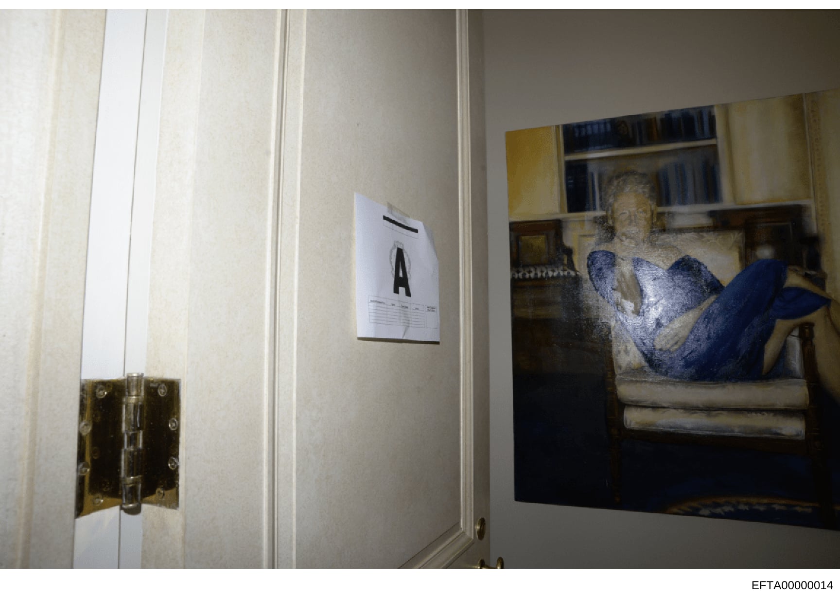 This is a photograph of an interior room showing a doorway with brass hinges, an evidence marker labeled 'A' on the wall, and a framed artwork depicting a reclining figure in blue tones displayed on the wall. The image appears to be part of a forensi