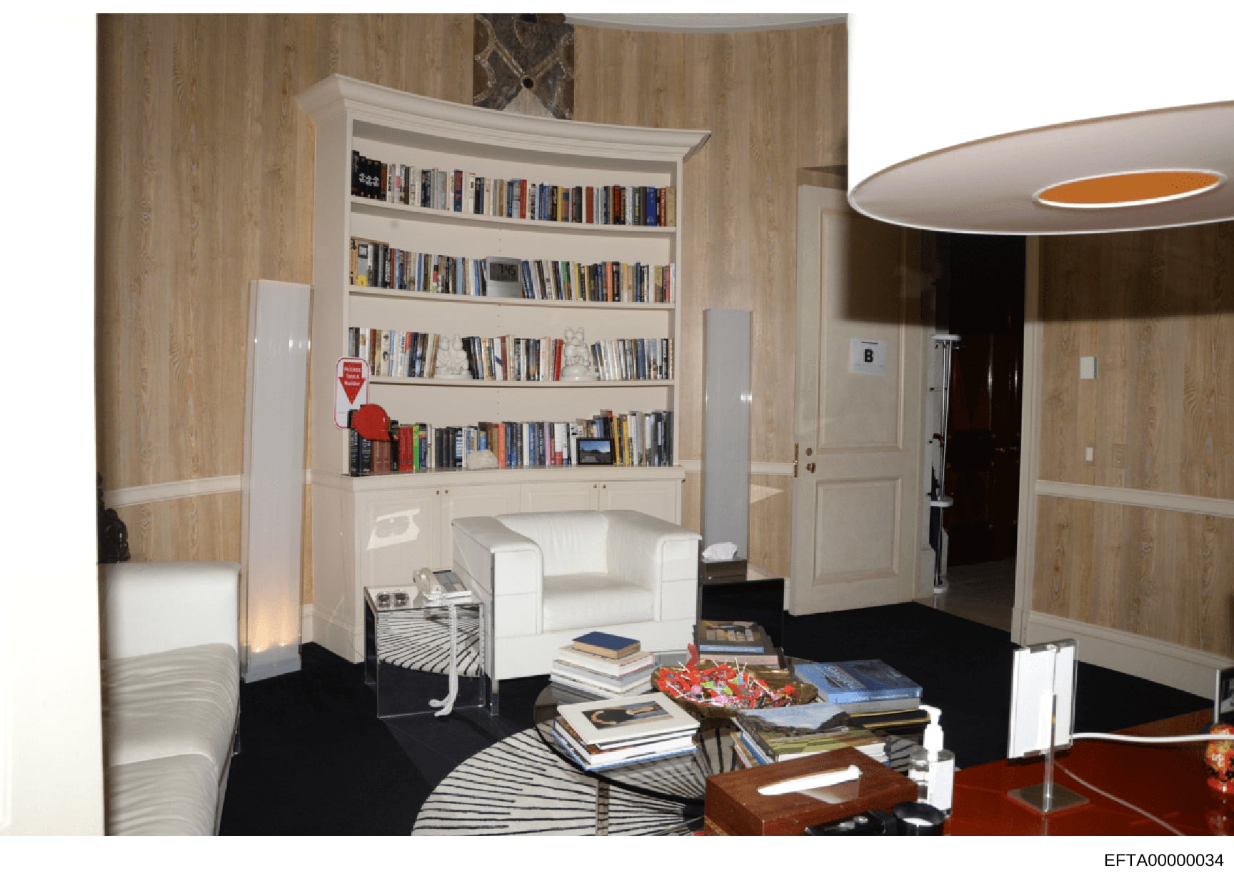 This is a professional 3D interior design rendering or architectural visualization showing a modernly furnished residential room with built-in bookshelves, seating area, and contemporary furnishings. The image appears to be part of property documenta
