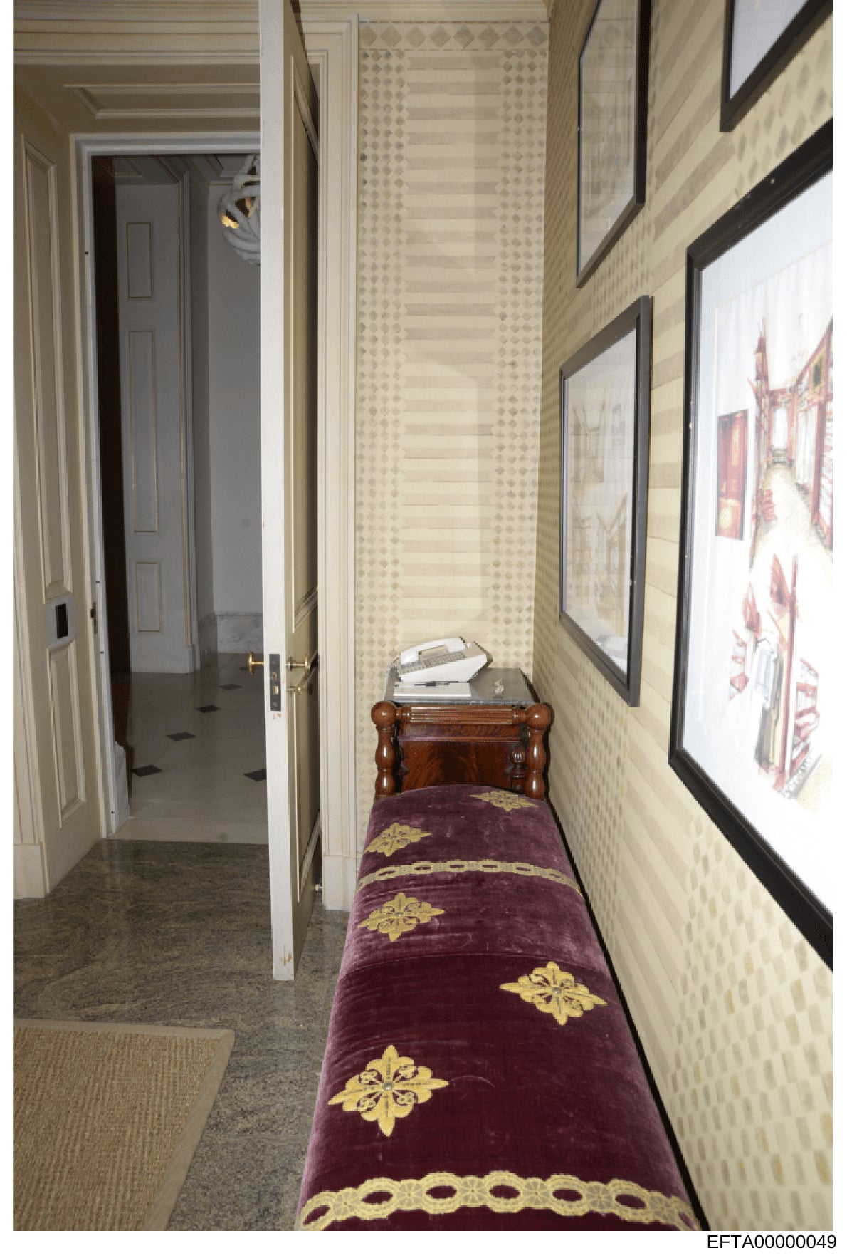 This photograph shows an elegant residential hallway, likely from one of Jeffrey Epstein's properties. The image depicts a long, narrow corridor with cream-colored wallpapered walls, framed architectural drawings or prints on the right side, and a di