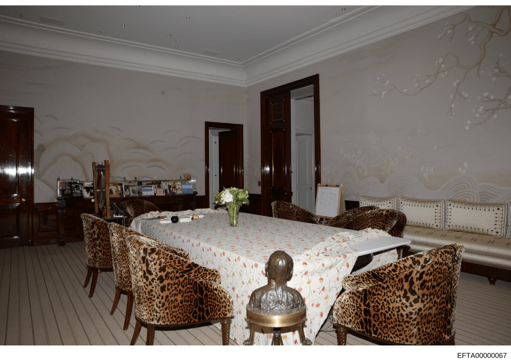 This is an evidence photograph showing an interior room with formal dining setup, featuring leopard-print upholstered chairs, a large dining table with decorative tablecloth, and high-end furnishings. The room displays ornate crown molding, dark wood