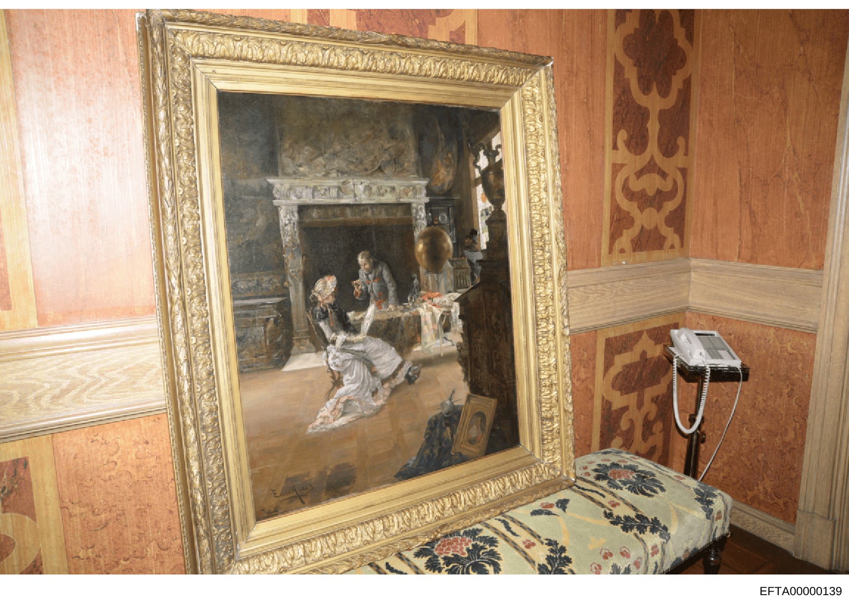 This is a photograph of an interior room, likely from one of Jeffrey Epstein's properties, showing an ornately framed classical painting depicting a historical or mythological scene. The room features period wallpaper with damask patterns, decorative