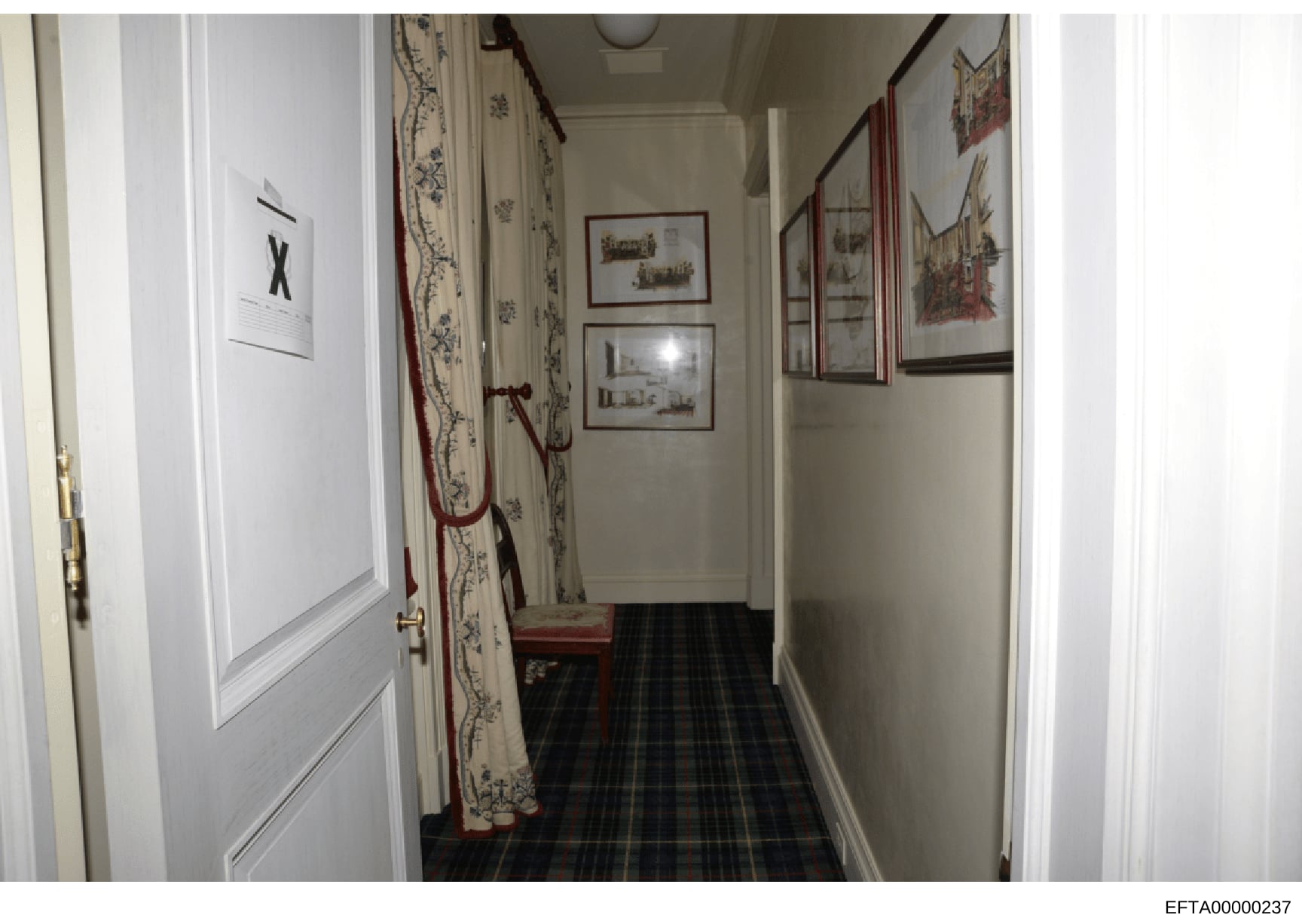 This is a photograph documenting an interior hallway in what appears to be one of Jeffrey Epstein's properties. The image shows a narrow corridor with decorative wall coverings, framed artwork, and furnishings. Such property photographs were typicall