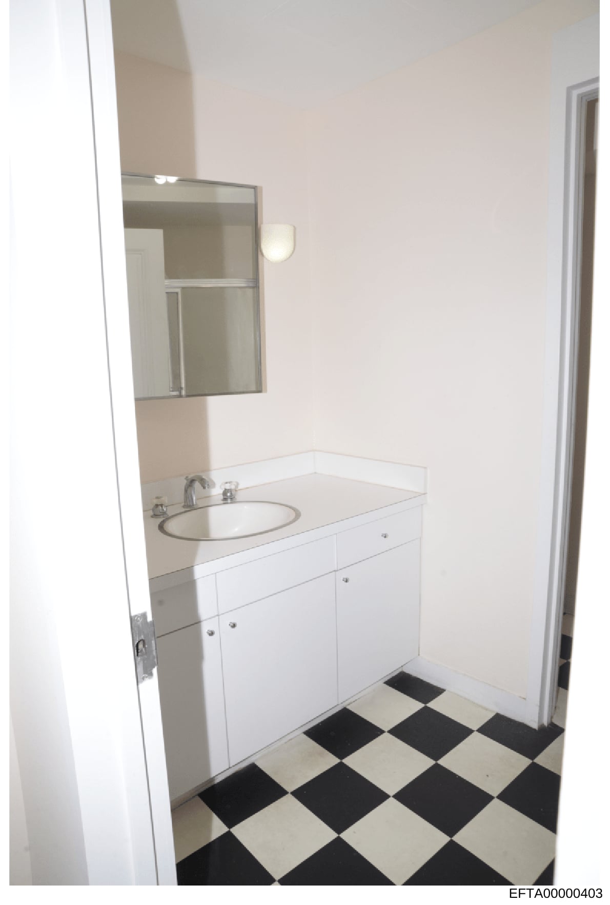 This is a photograph of a residential bathroom showing a vanity sink setup with white cabinetry, mirror, and black-and-white diamond patterned floor tiling. The image appears to be part of property documentation or evidence photography related to one