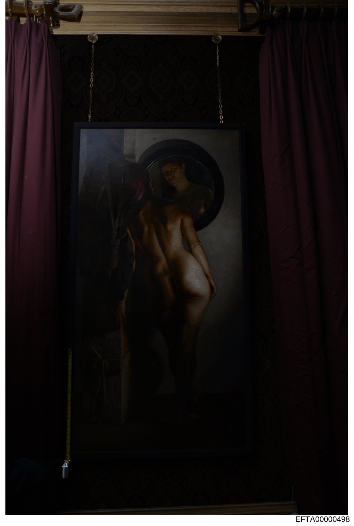 This is a photograph of a framed artwork displayed in an interior space with purple curtains. The painting depicts a figure wearing a wide-brimmed hat in a classical artistic style. The photograph appears to be evidence documentation from a property