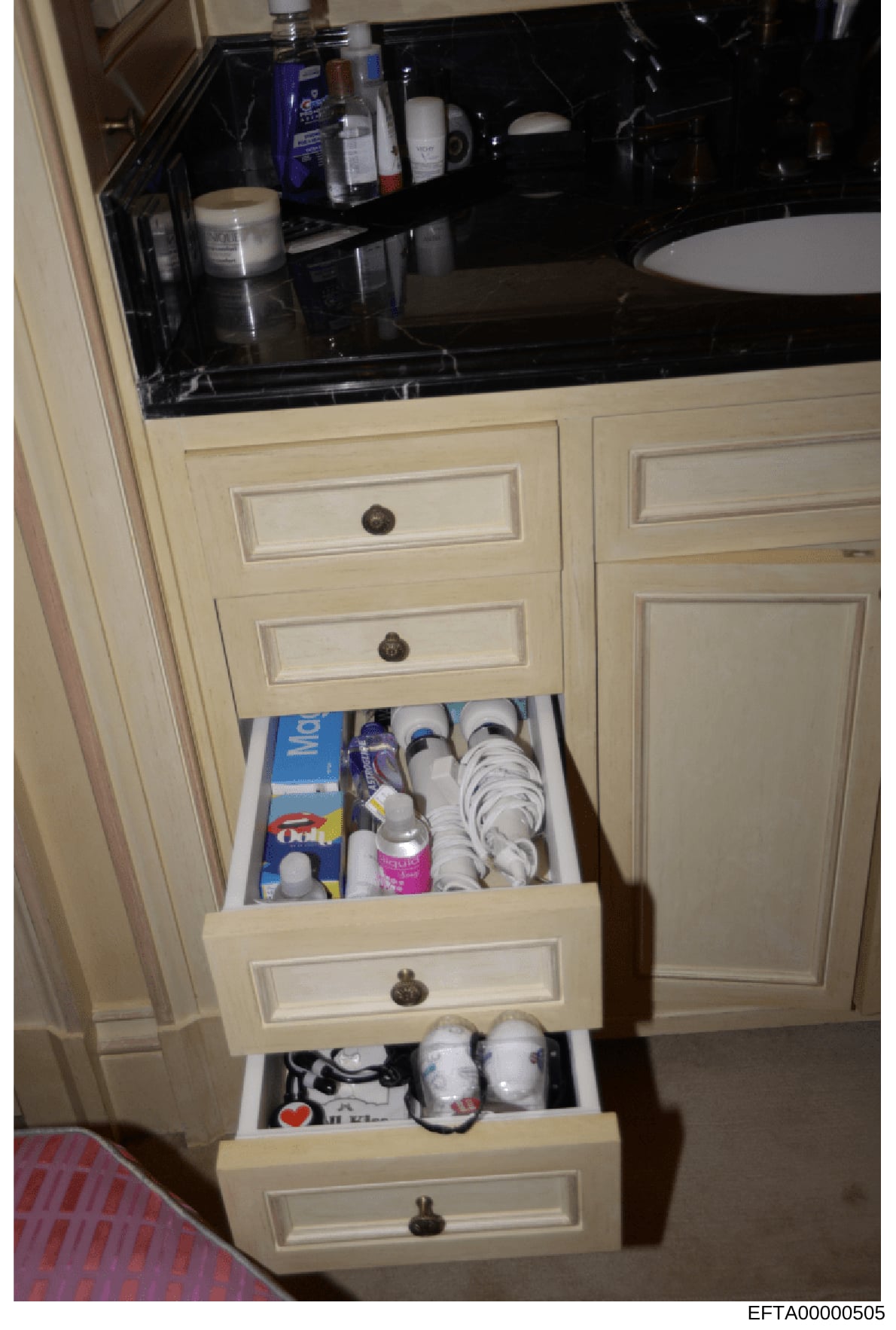 This photograph documents the contents of a cream-colored cabinet with multiple drawers, showing personal hygiene products, toiletries, and household items. The image appears to be evidence documentation from one of Epstein's properties, with drawers