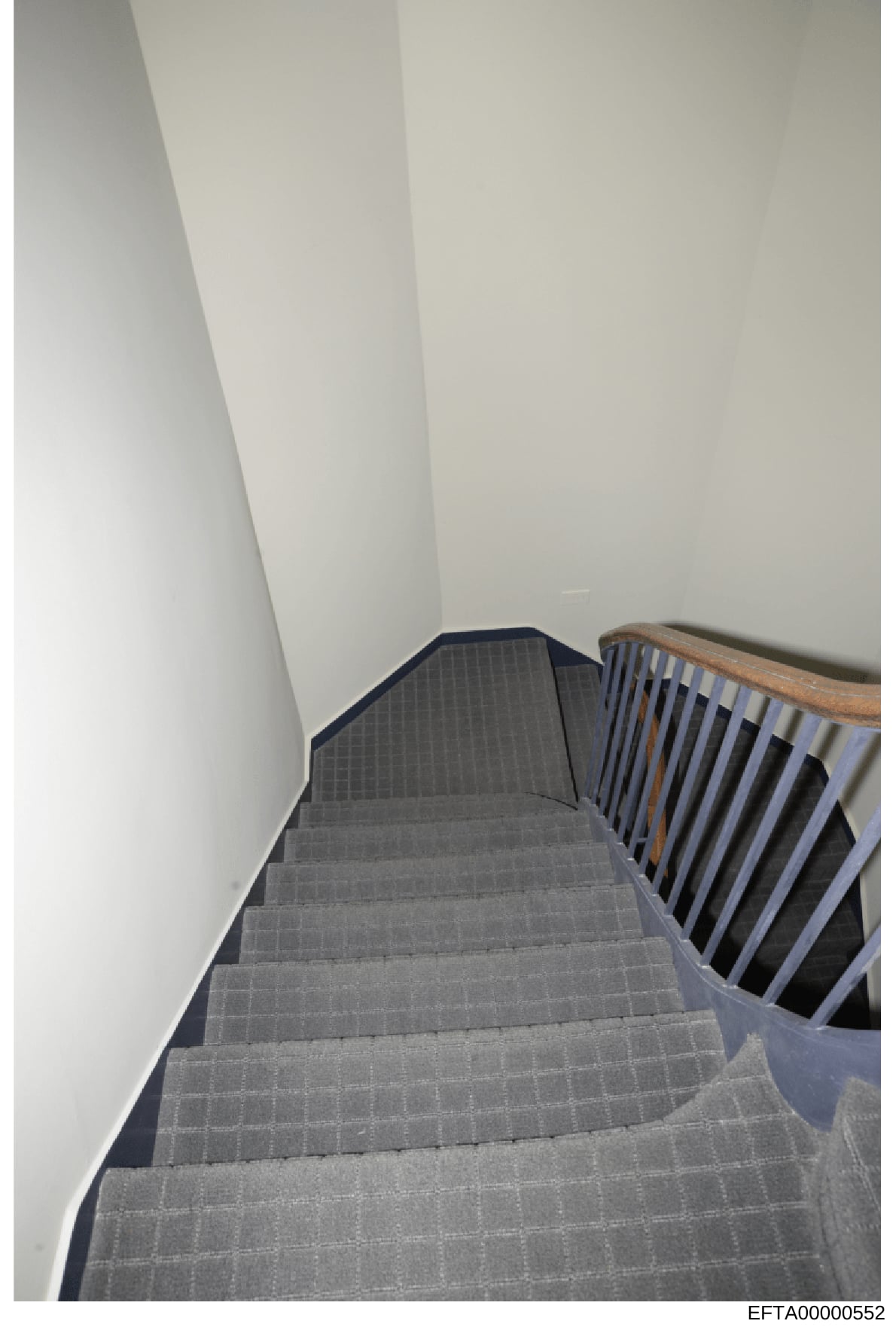 This is a photograph of an interior staircase with gray carpeting and wooden handrails, showing the architectural interior of what appears to be a residential or commercial property. The image is part of evidence documentation related to the Epstein