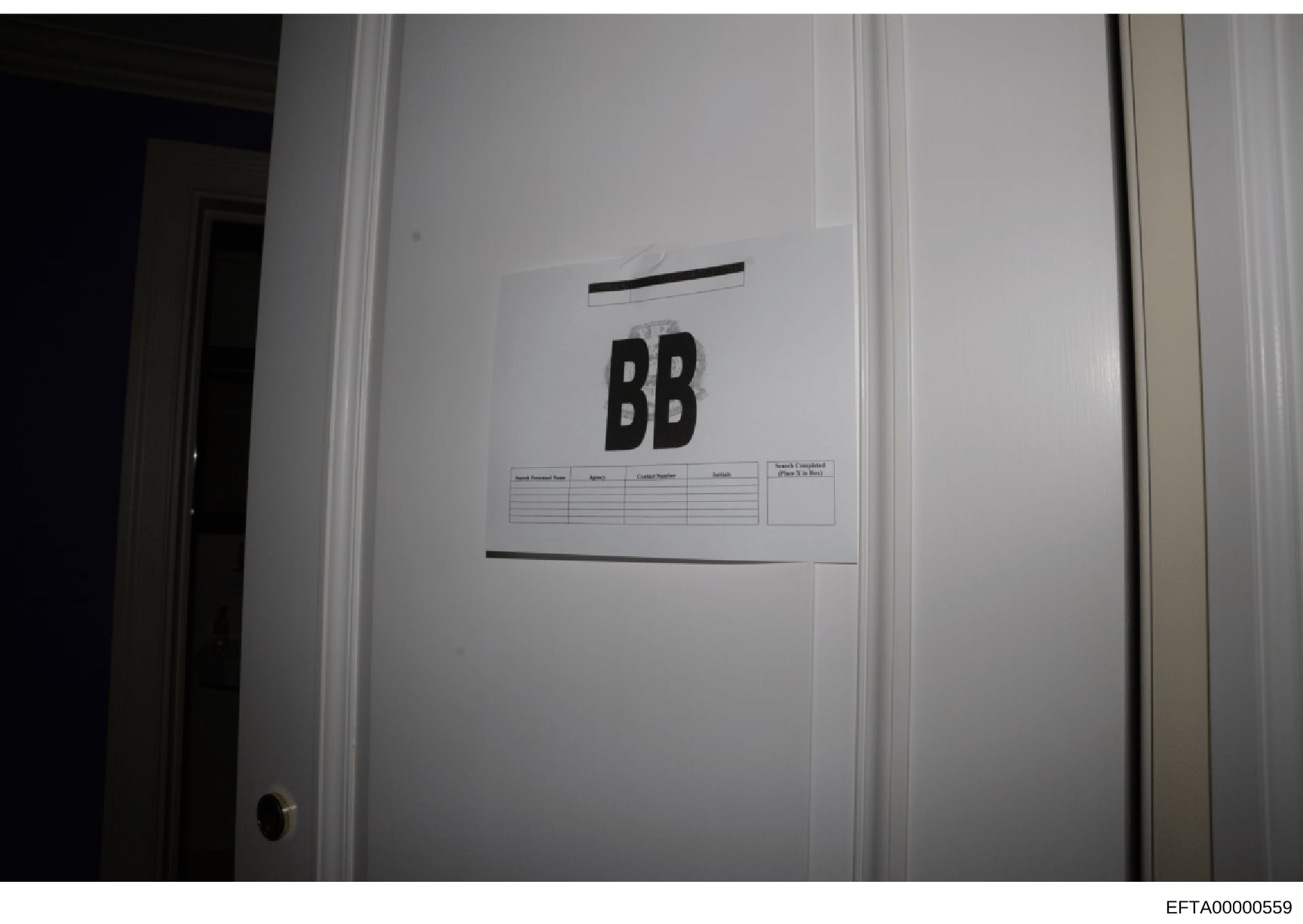 This is an evidence photograph showing a white interior door marked with large black letters 'BB' and attached documentation forms. The label and forms suggest this door was part of a systematic search and cataloging process during the investigation,