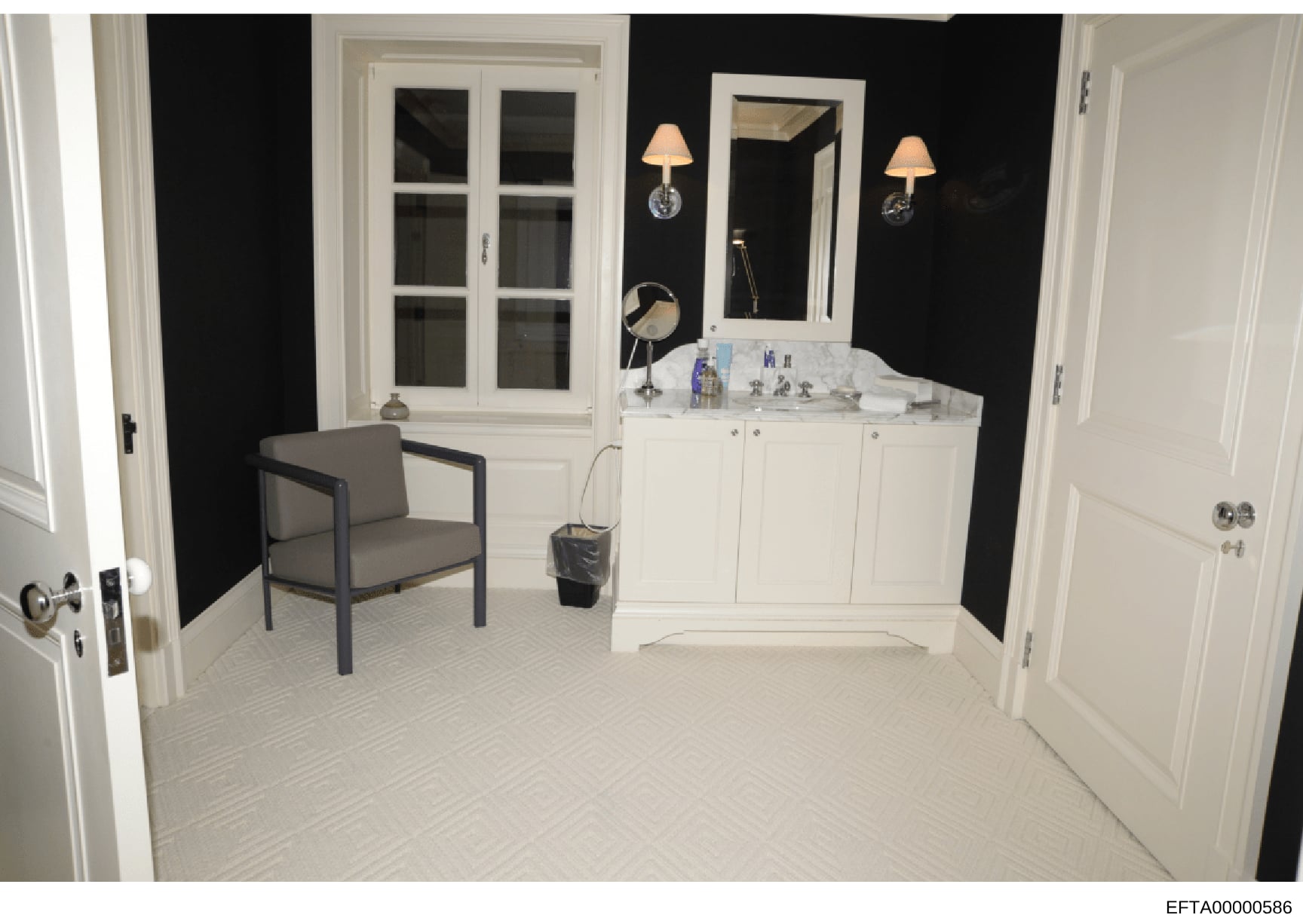 This is a photograph of an upscale bathroom interior featuring a large white vanity with marble countertop, dual wall sconces, and contemporary decor. The room displays high-end finishes consistent with luxury residential property documentation, like