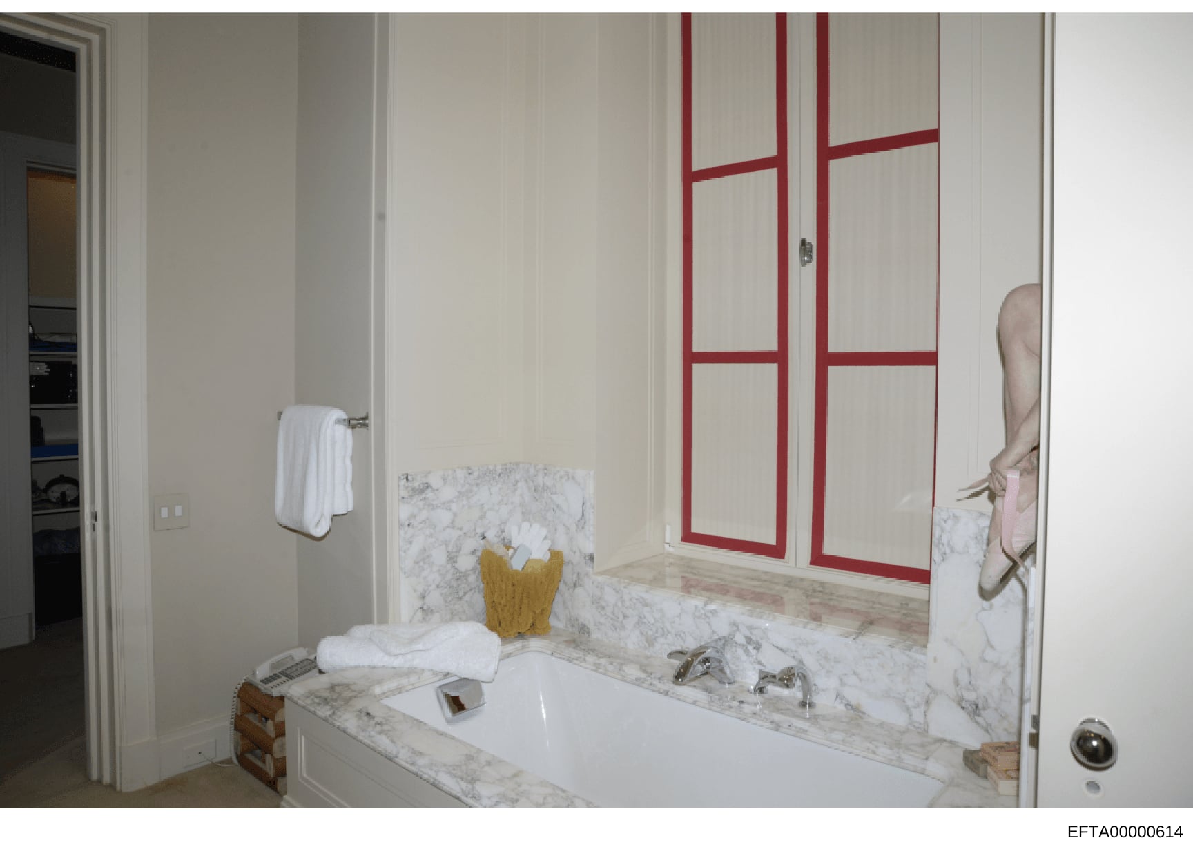 This is a photograph of a luxury bathroom interior, featuring a marble-topped vanity sink, red-framed mirrored medicine cabinet, and white towel rack. The image appears to be evidence documentation from property inspection, showing the interior desig
