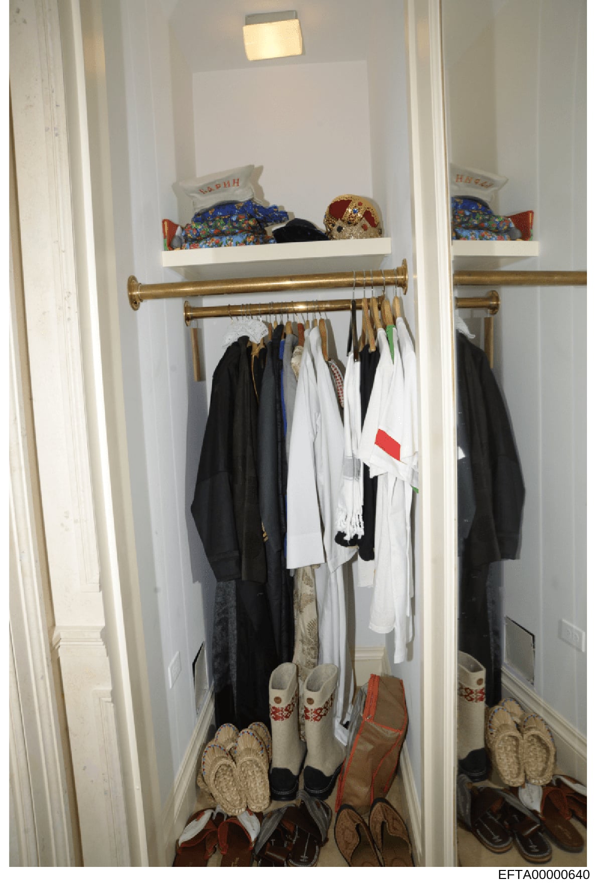 This is an evidence photograph showing the interior of a closet space containing clothing, footwear, and decorative items on shelves. The image appears to be part of the investigative documentation of a residence, likely taken during a search or inve