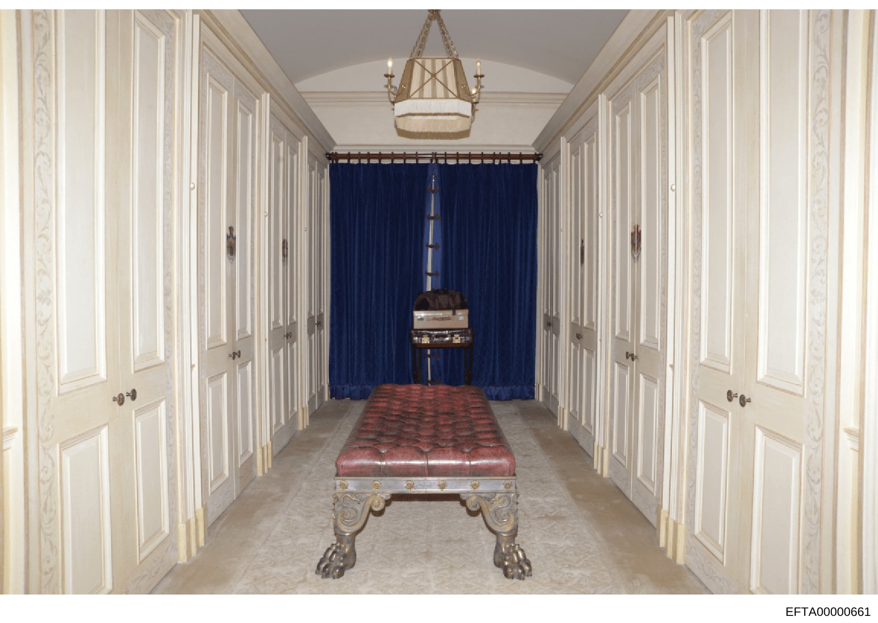 This photograph documents the interior of a luxury property, showing an elegantly appointed hallway with classical architectural details. The image features a billiards table with a red leather surface positioned in the center of the space, flanked b