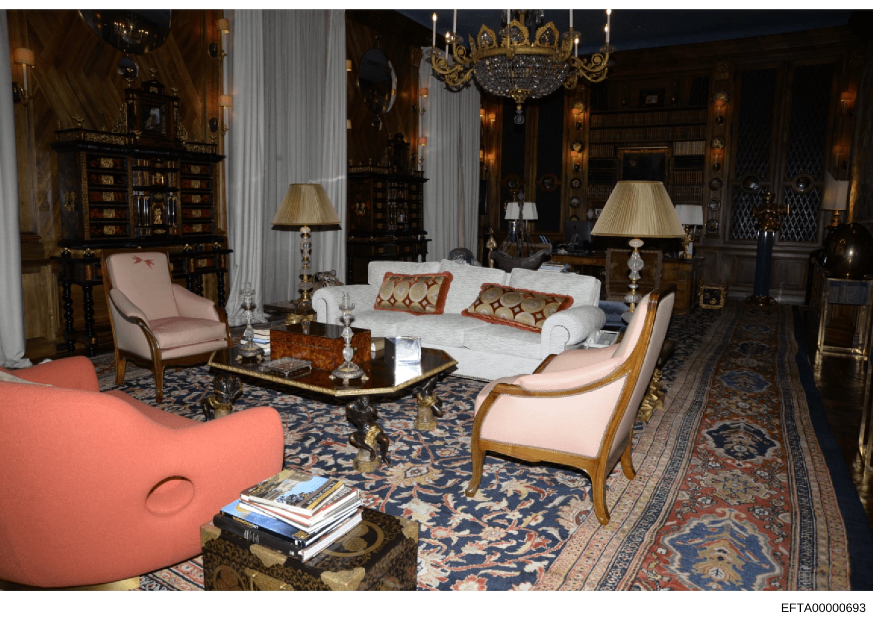 This is an evidence photograph depicting the interior of a high-end residential property, showing an ornately decorated living room or salon with classical furnishings, including pink upholstered chairs, a white sofa, decorative pillows, elaborate ch