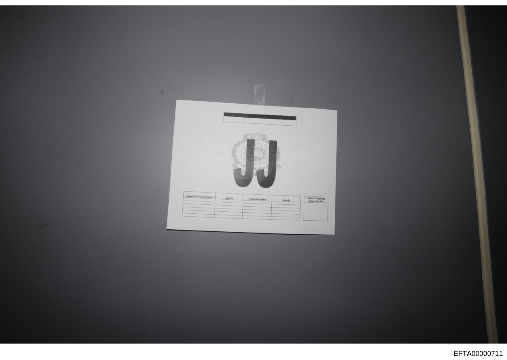 This is an evidence photograph showing a document marked with large 'JJ' initials at the center. The document contains a table with columns for 'Search Personnel Name,' 'Agency,' 'Contact Number,' 'Initials,' and 'Search Completed (Date & Time).' The