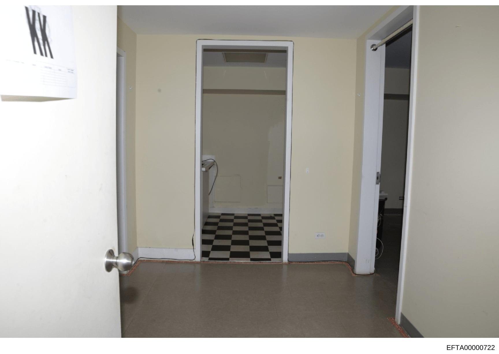 This is a photograph of an interior bathroom or utility space, showing cream-colored walls, multiple doorways, and a distinctive black and white checkered tile floor. The image appears to be part of the evidence documentation from the Epstein investi