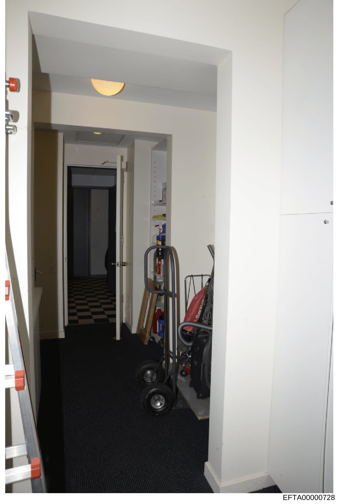 This is an evidence photograph showing an interior hallway or utility closet space in what appears to be a residential property. The image depicts stored equipment including dollies, a red stroller, and various maintenance items. The space has white