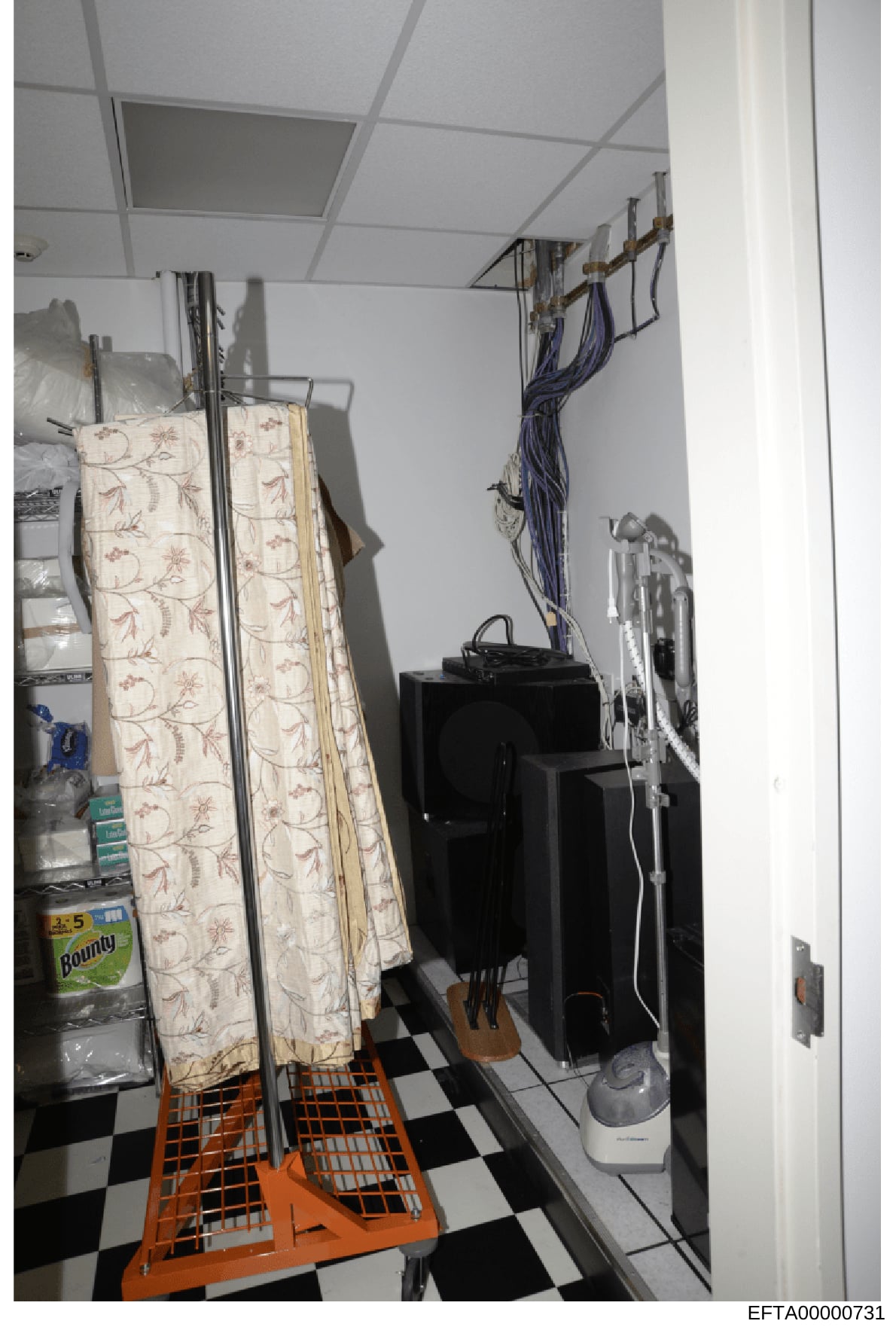 This is an evidence photograph showing an interior utility or storage room, likely from one of Jeffrey Epstein's properties. The image depicts a small enclosed space with a drop ceiling, black and white checkered flooring, and various household items
