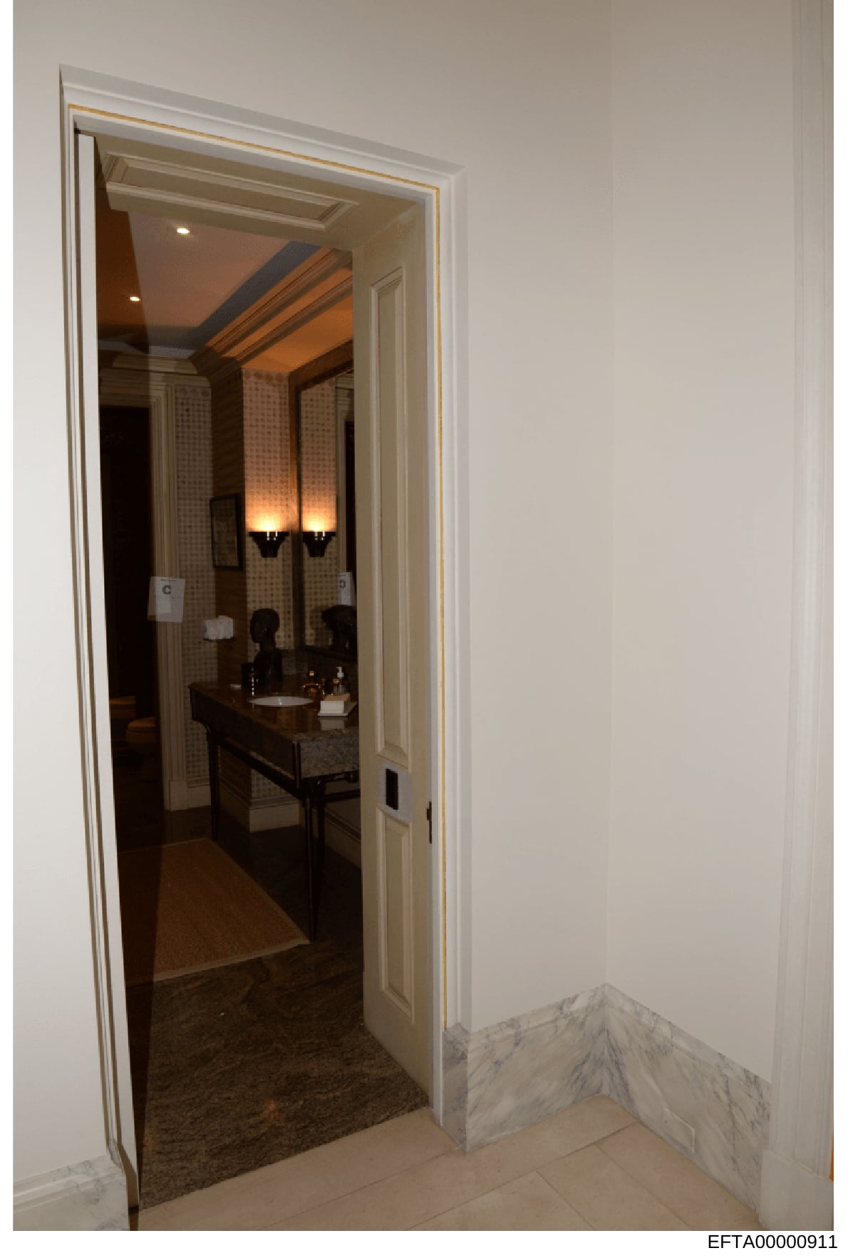 This photograph documents the interior of an upscale bathroom, showing a sophisticated ensuite with double vanity, decorative lighting, and high-end finishes. The image appears to be part of property documentation, possibly from one of Jeffrey Epstei