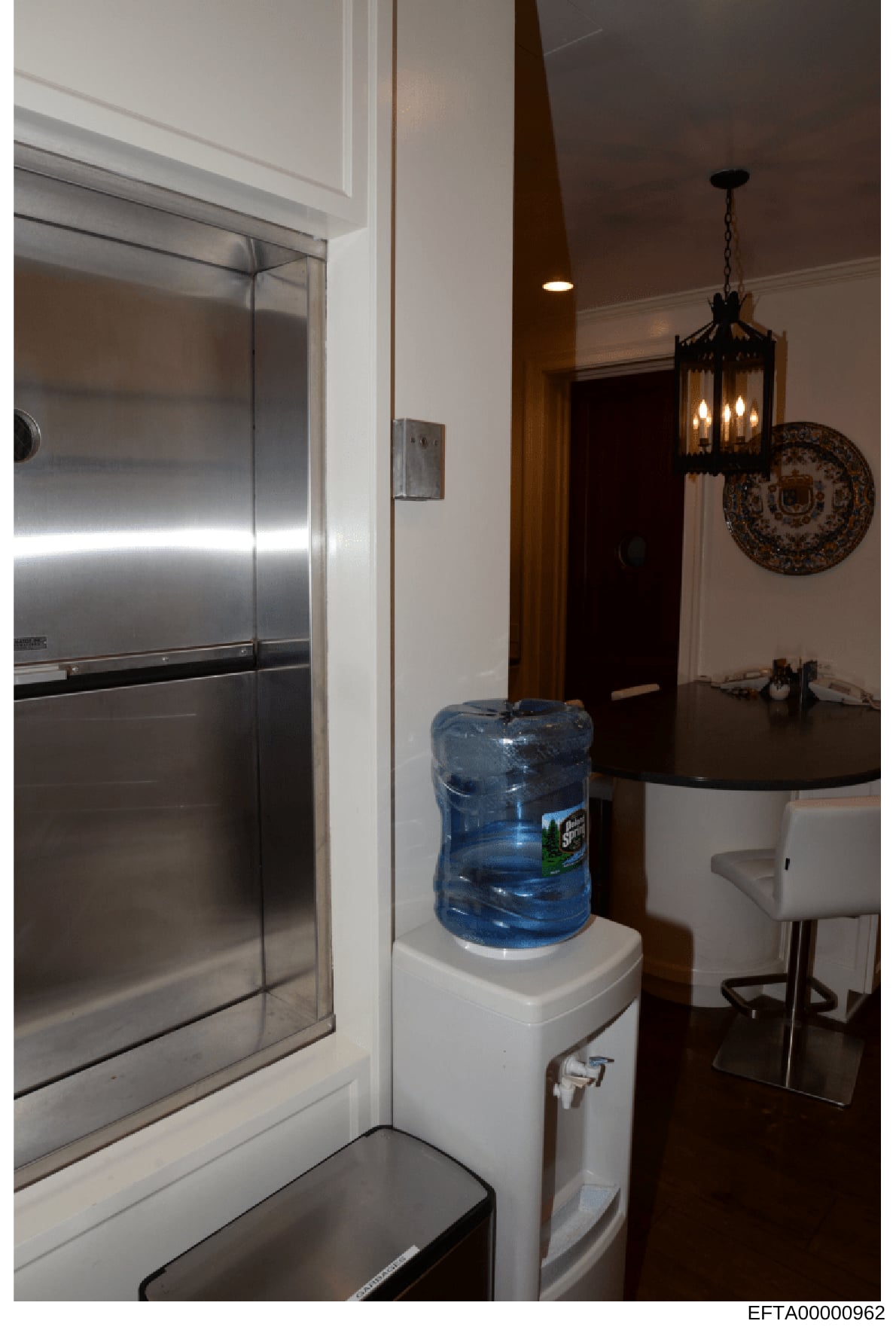This is a photograph of an interior residential space showing a hallway with a bathroom entrance on the left and a kitchen/dining area on the right. The image appears to be from property documentation, showing fixtures including a shower enclosure, w
