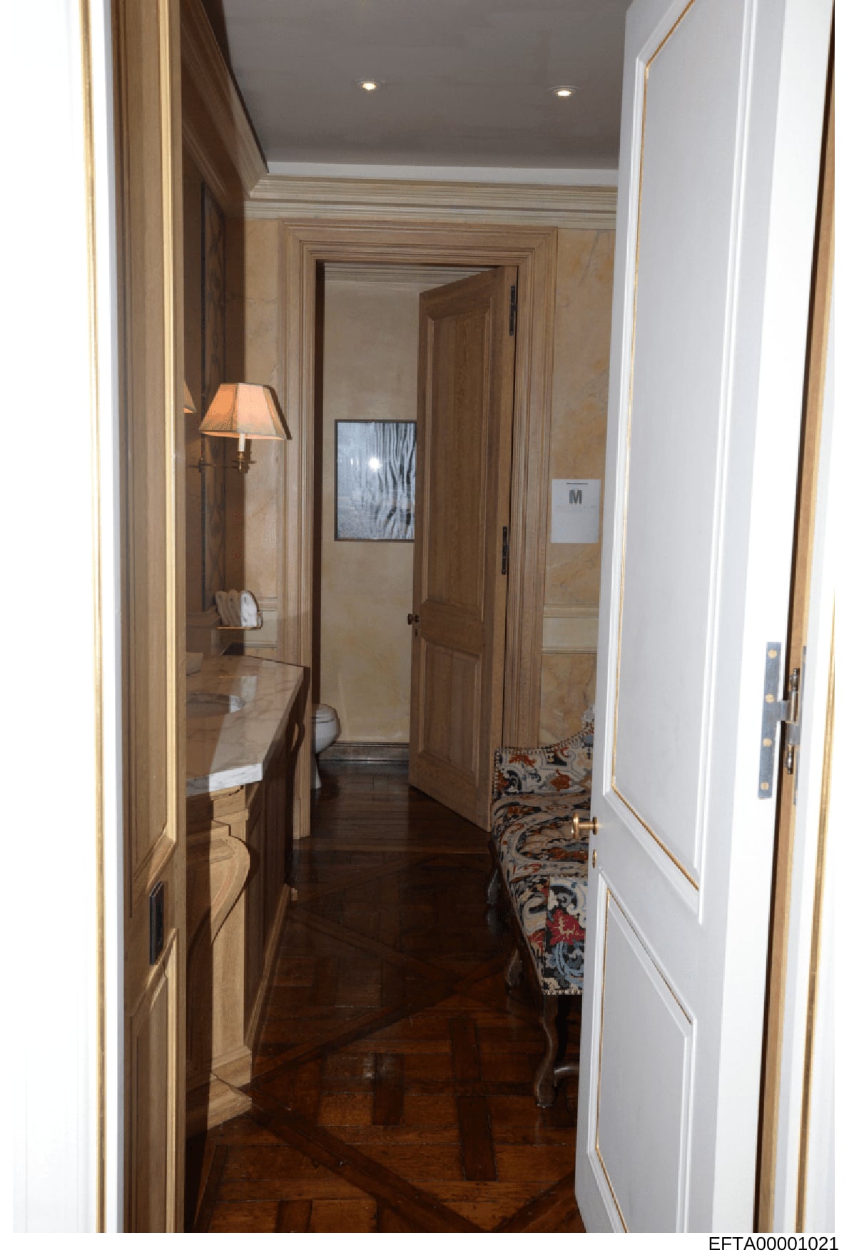This photograph shows an upscale residential hallway featuring elegant wood paneling, marble walls, recessed lighting, and high-end finishes. The image appears to be documentation of interior spaces from one of Jeffrey Epstein's properties, likely ta