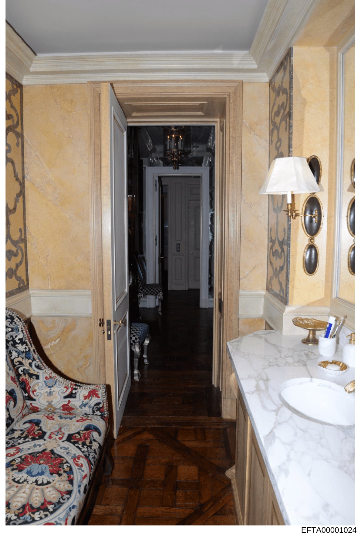 This is an evidence photograph showing the interior of an upscale bathroom, likely from one of Jeffrey Epstein's properties. The image documents the bathroom's luxurious design features including marble countertops, decorative wall treatments, brass