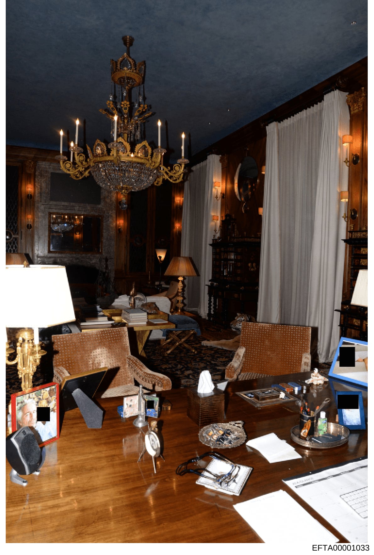 This is a photograph of an elegantly decorated office or study room featuring high-end furnishings, ornate décor, and luxury appointments. The room displays a gold-trimmed chandelier, wood paneling, marble fireplace, period furniture, and various per