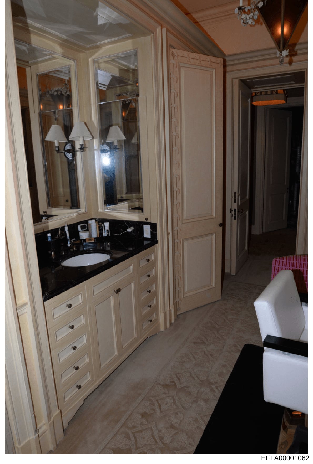 This is an evidence photograph documenting the interior of a luxury bathroom, featuring a custom-built vanity with black marble countertop, cream-colored cabinetry with multiple drawers, and large mirrored medicine cabinets with sconces. The photo ap