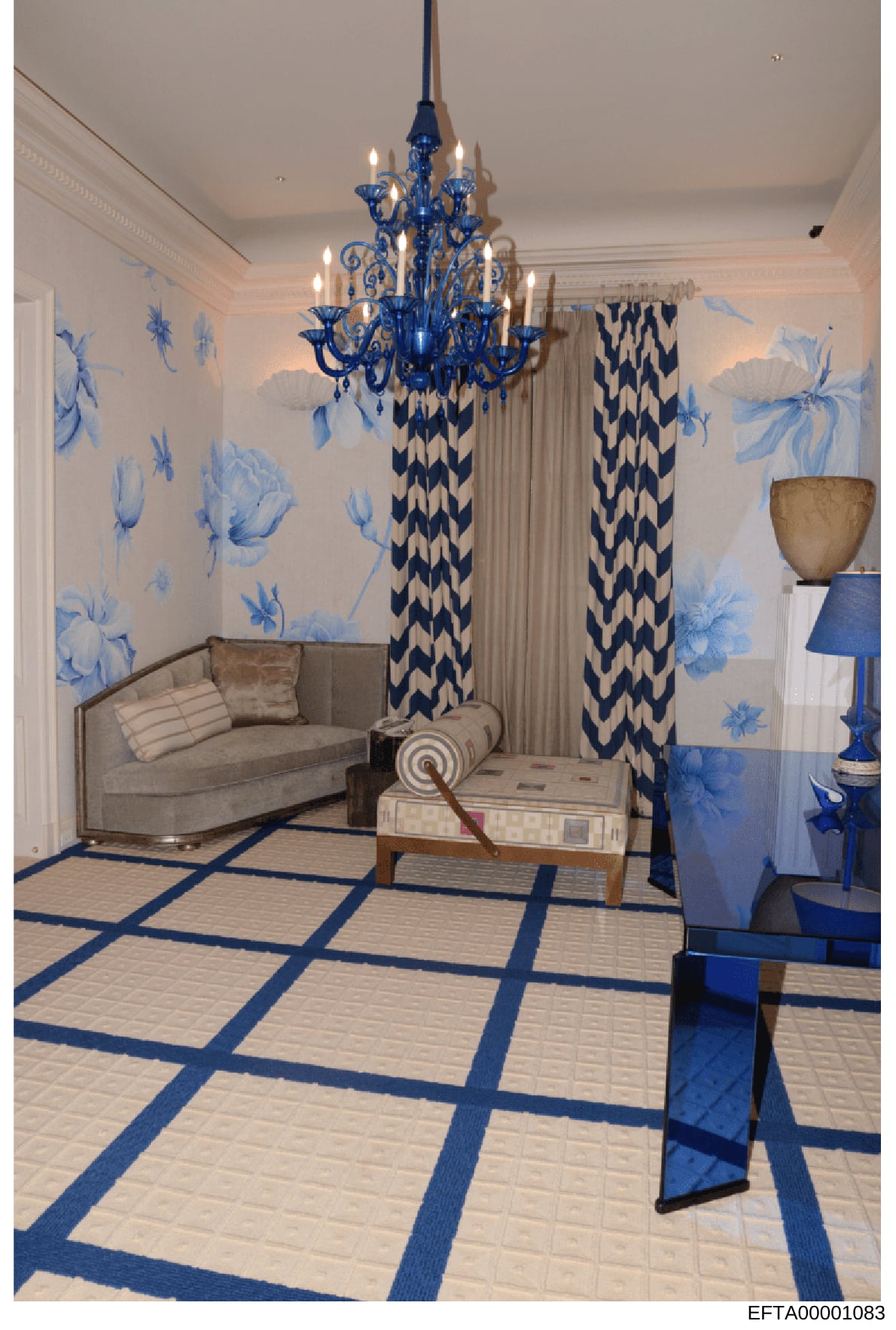 This is an architectural or interior design rendering depicting an elegantly decorated sitting room with a sophisticated blue and white color scheme. The room features a blue crystal chandelier, botanical wallpaper, geometric patterned curtains, a be