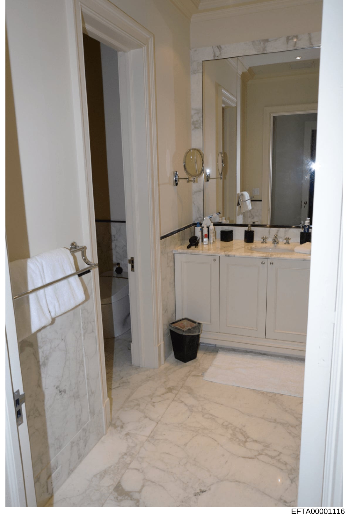 This is a photograph of an upscale bathroom interior, likely from one of Jeffrey Epstein's properties. The image shows a luxuriously appointed master bathroom with marble flooring and countertops, dual vanities, custom cabinetry, and high-end finishe