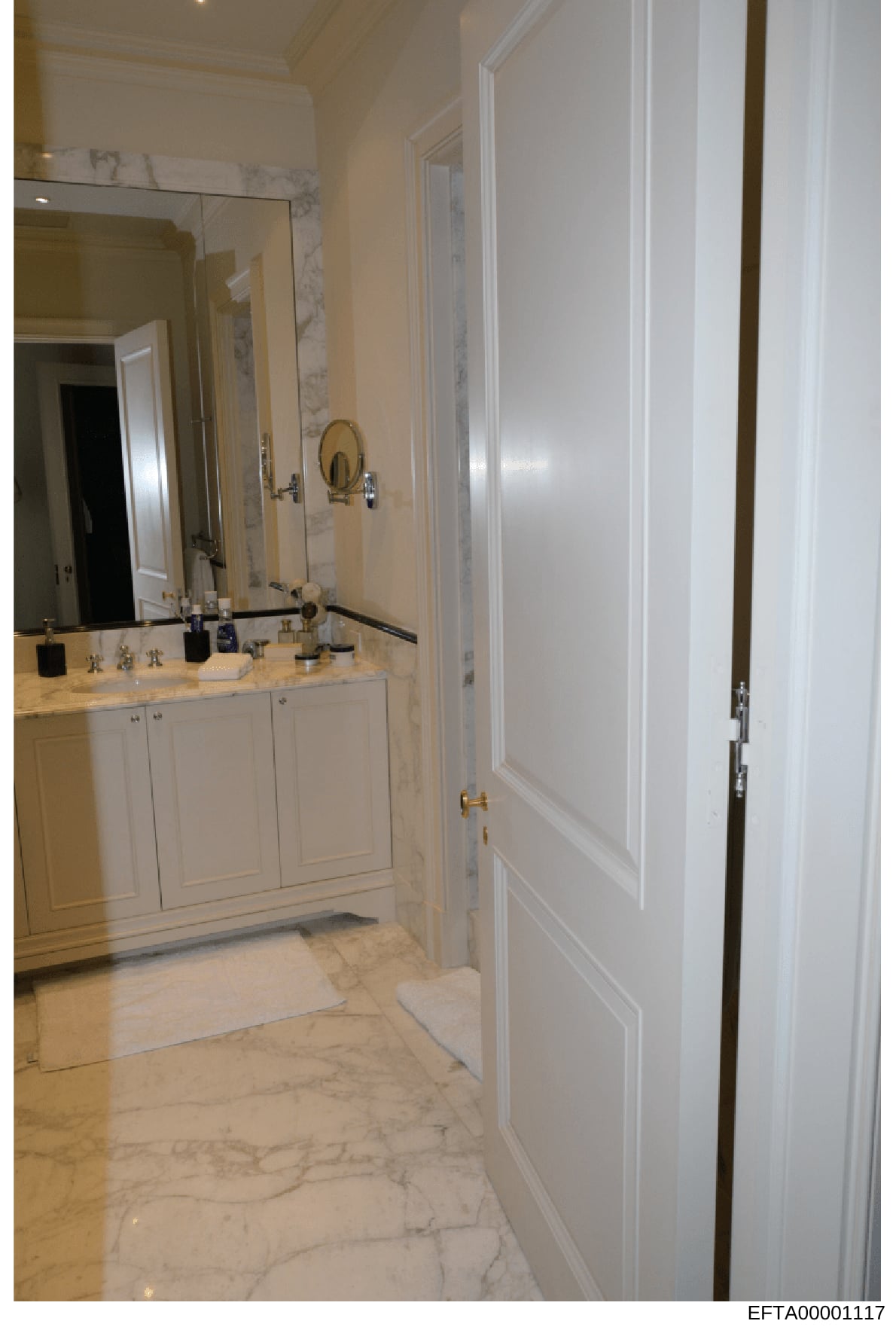 This is a photograph of an upscale bathroom interior featuring marble flooring, dual vanities with white cabinetry, large mirrors, and brass fixtures. The image appears to be documentation of property interiors, likely from one of Epstein's residence