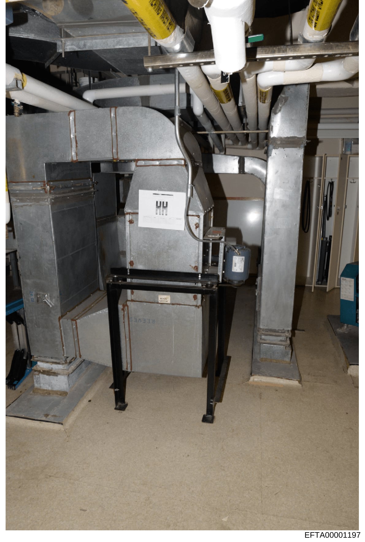 This is an evidence photograph showing HVAC (heating, ventilation, air conditioning) equipment and ductwork in what appears to be a basement or mechanical room. The image documents the property's mechanical systems, including furnace units, piping, a