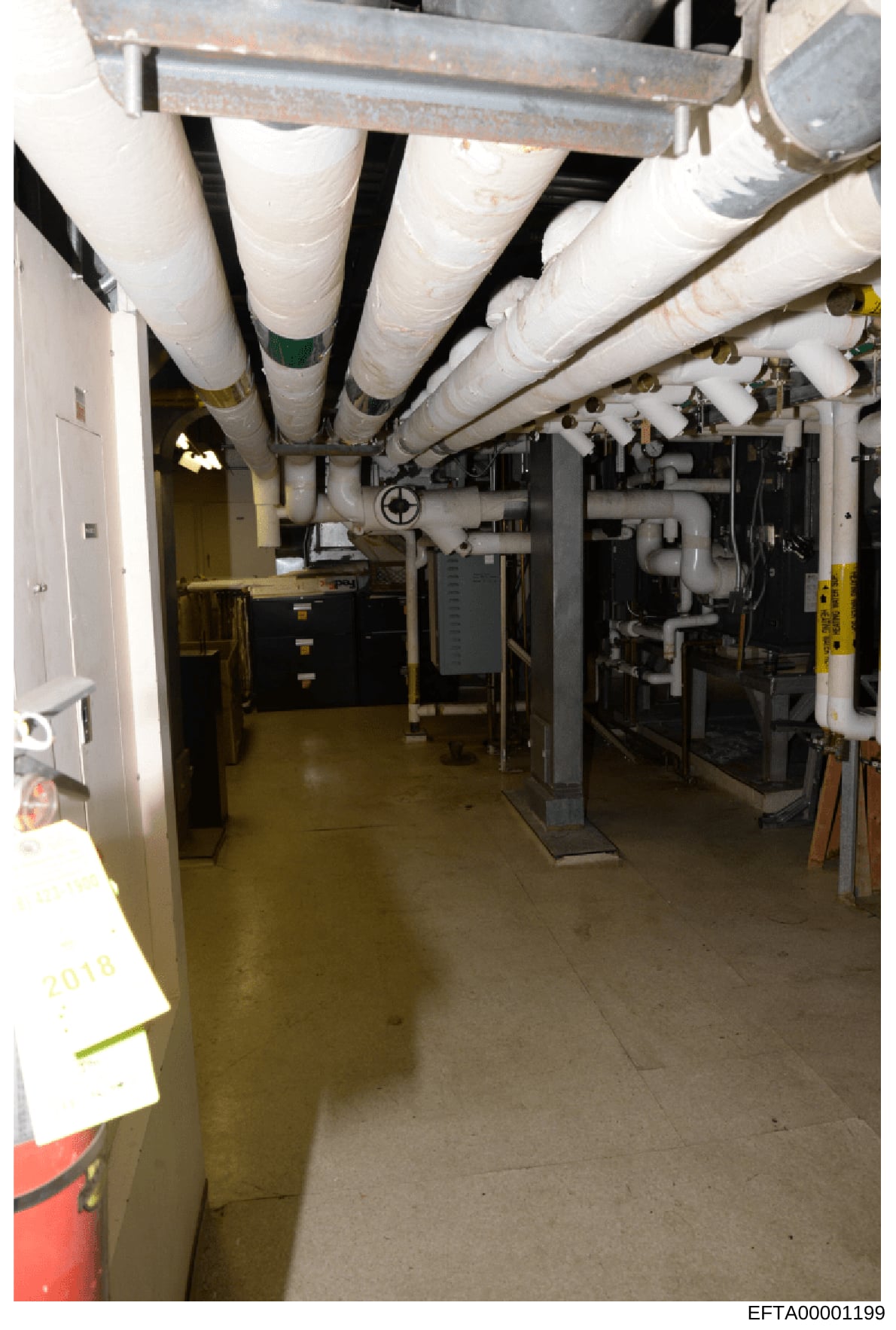 Photograph of a basement mechanical/utility room showing extensive HVAC ductwork, piping systems, and equipment installation. The image documents the infrastructure of what appears to be a residential property, with wrapped insulation on large diamet