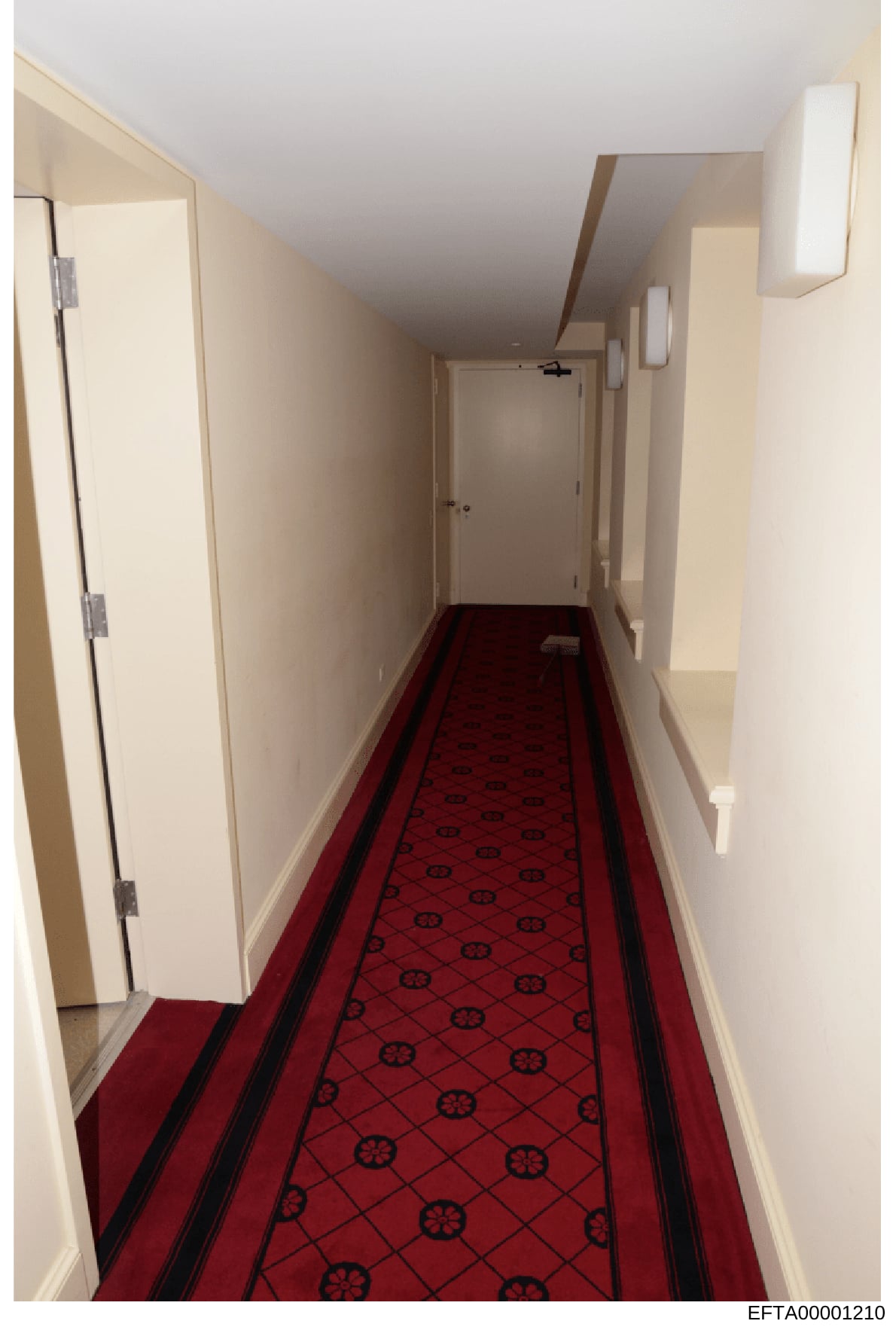This photograph shows an interior hallway, likely from one of Epstein's properties, featuring cream-colored walls, recessed lighting, and a distinctive red carpet with a repeating black geometric pattern (ship wheel motif). Multiple white doors line