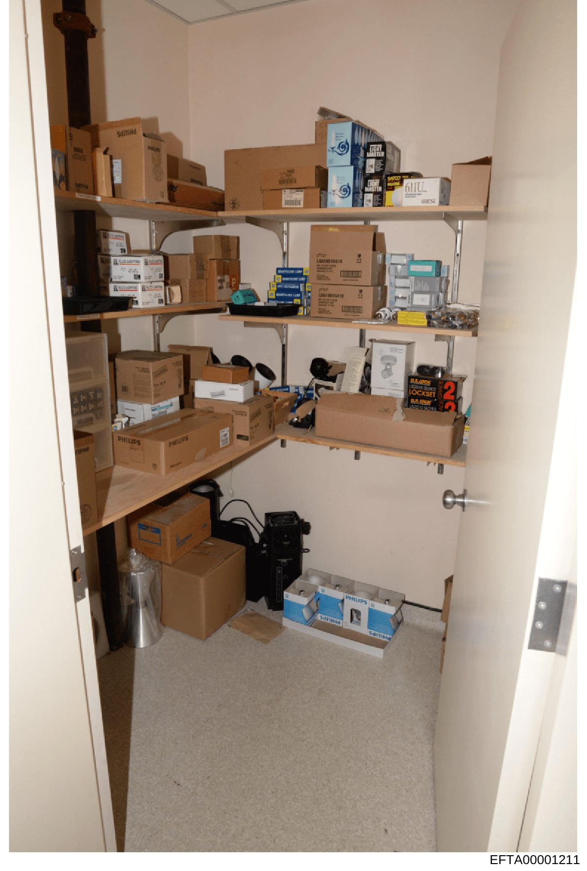 This is an evidence photograph showing the interior of a storage closet containing multiple cardboard boxes and equipment, likely from one of Epstein's properties. The closet contains various packaged items including Philips-branded boxes, electronic