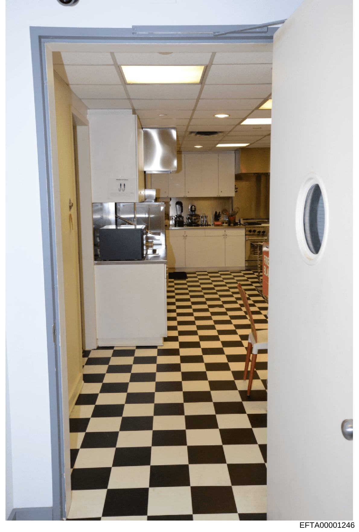 This photograph documents the interior of a residential kitchen, showing appliances, cabinetry, and flooring. The image appears to be evidence photography from a property inspection or inventory associated with the Epstein investigation. The kitchen