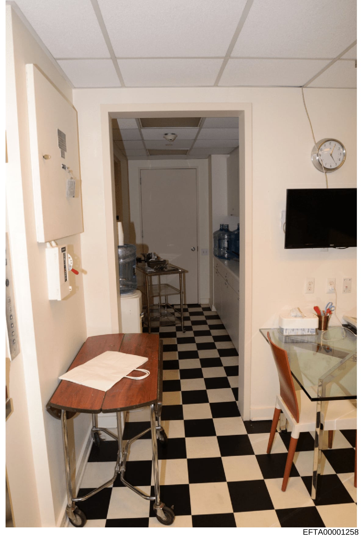 This is a photograph of an interior kitchen and hallway space, showing the layout and furnishings of what appears to be a residential property. The image captures details of appliances, flooring, cabinetry, and general room configuration that may be 