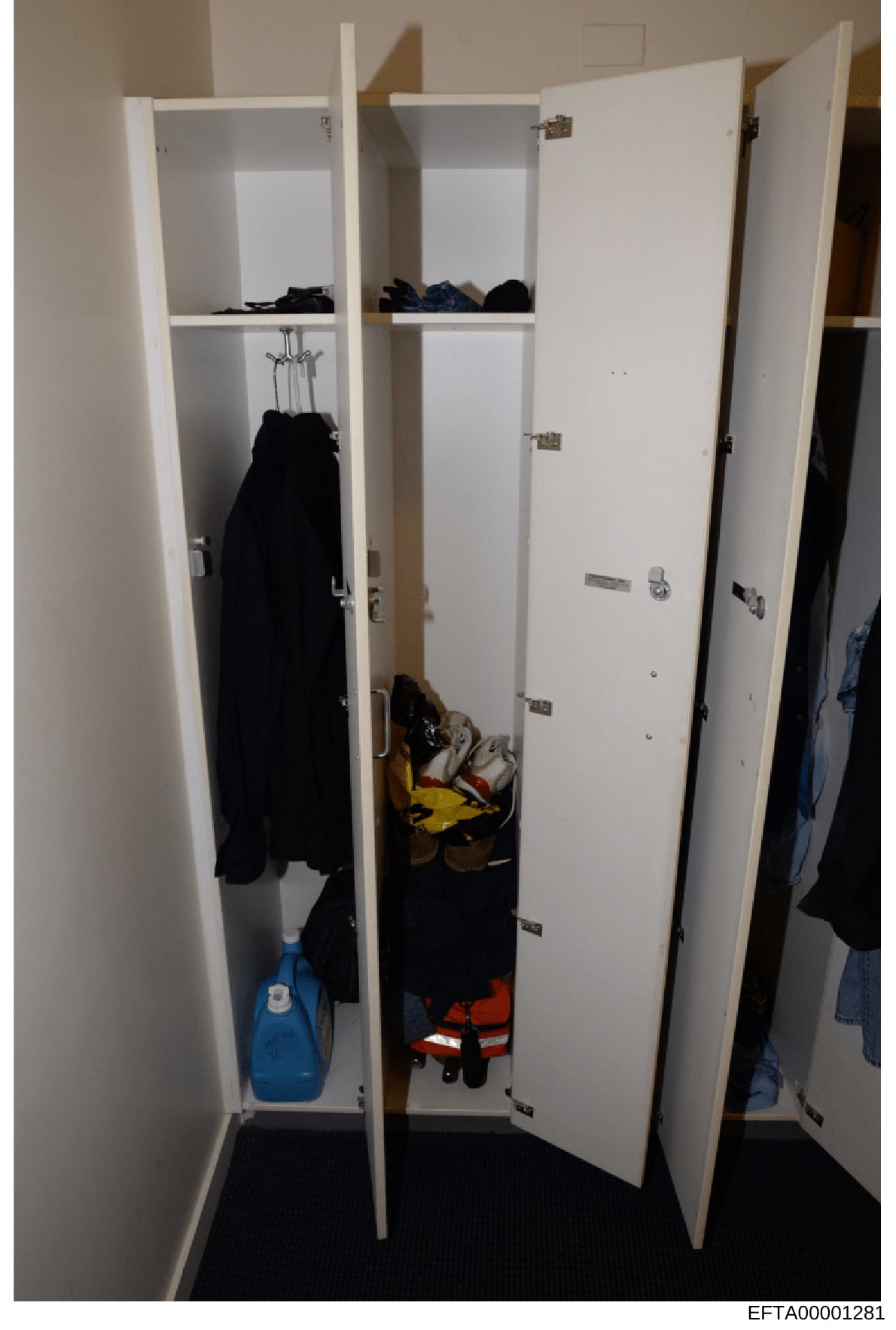 This is an evidence photograph showing the interior of a white built-in wardrobe or closet cabinet containing various clothing items, shoes, and personal belongings. The photo documents the contents and condition of storage space, likely from one of