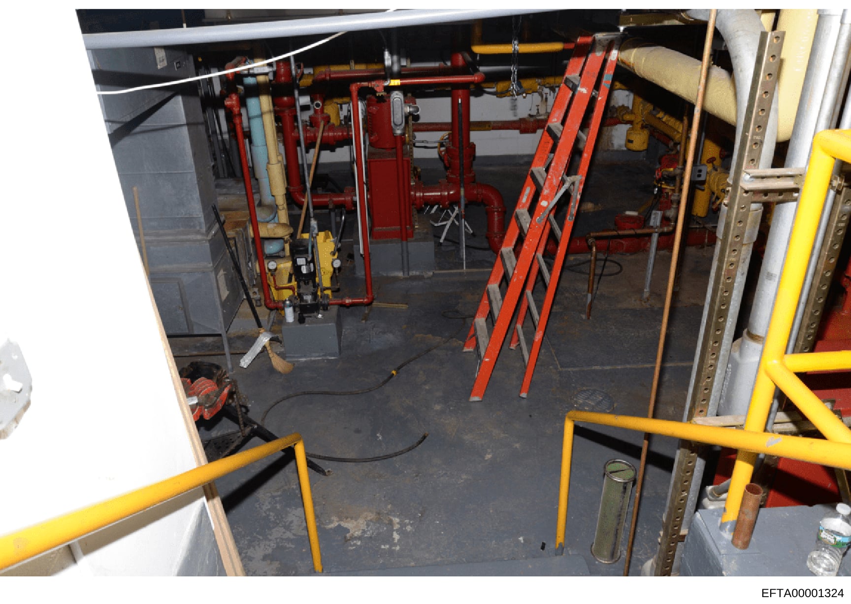 This photograph shows an interior mechanical or engine room with industrial fire suppression systems, HVAC equipment, and various piping infrastructure. The image captures red and yellow safety equipment, including what appears to be fire suppression