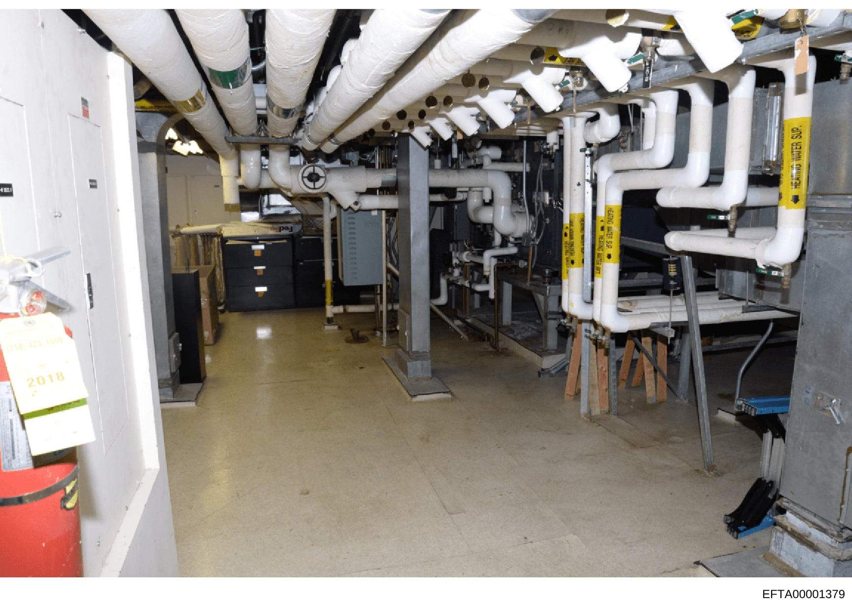 This photograph shows the basement mechanical infrastructure of a property, featuring HVAC systems, plumbing pipes, heating equipment, and various utility installations. The image documents the building's mechanical systems and may be relevant to pro