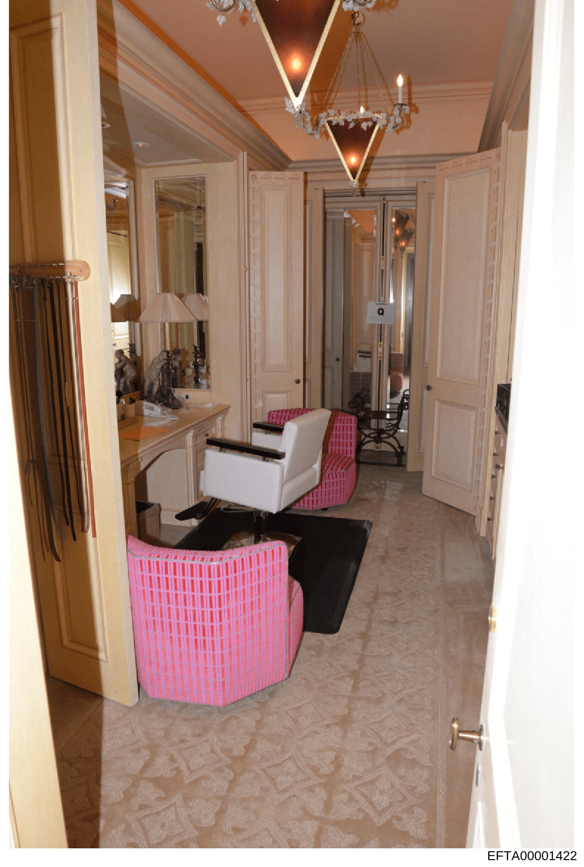 This photograph shows an elegantly decorated dressing room or walk-in closet featuring custom cabinetry, mirrors, plush furnishings, and professional lighting. The space displays high-end interior design with coordinated pink and white upholstered se