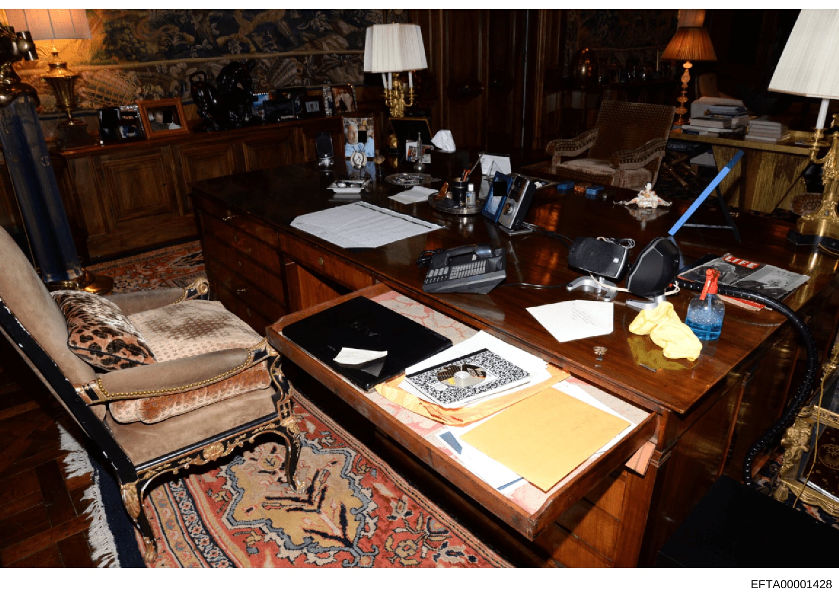 This photograph depicts the interior of what appears to be Jeffrey Epstein's private office, showing a luxuriously furnished workspace with mahogany desks, expensive décor, and various personal items and documents. The image captures the opulent envi