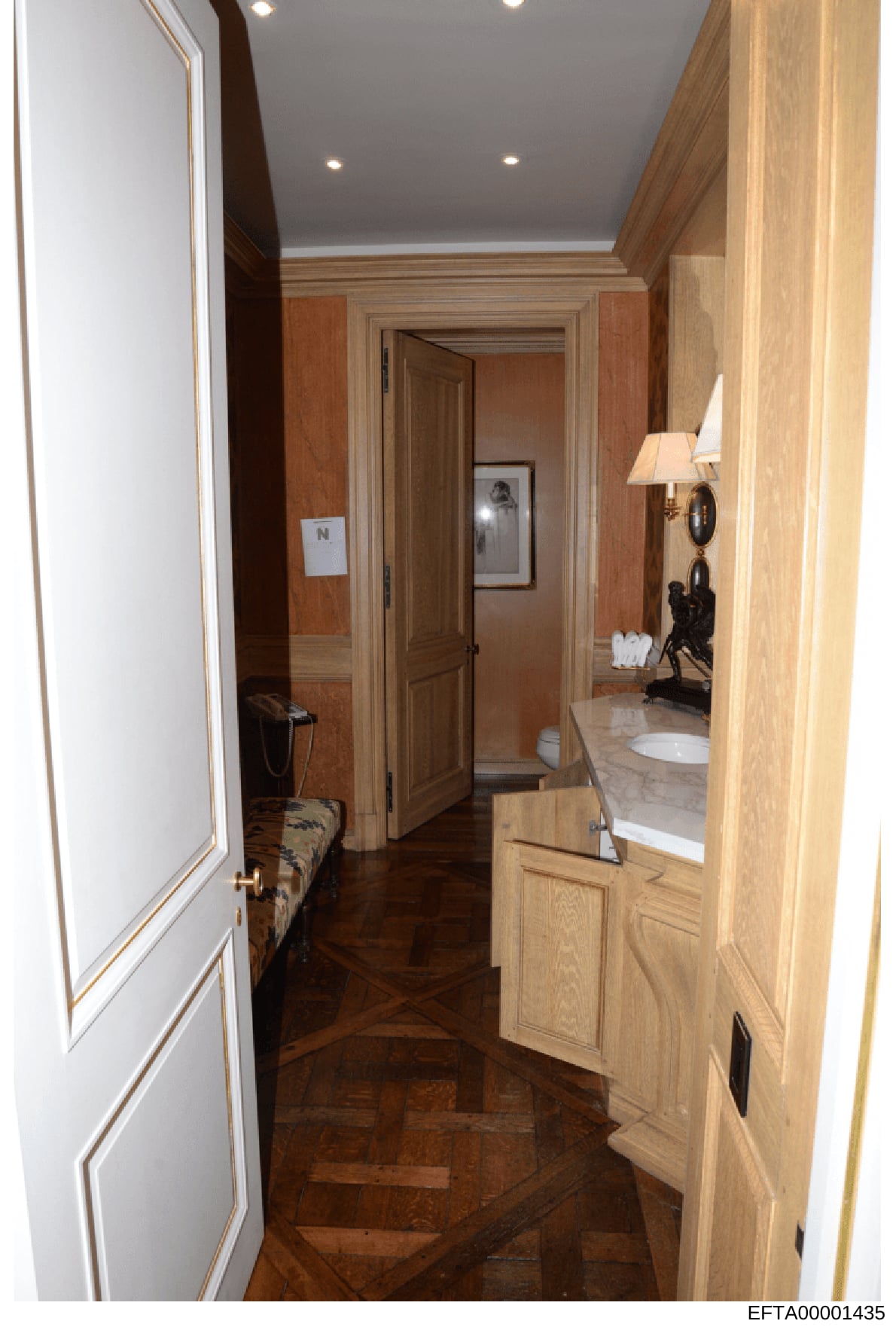 This is an evidence photograph showing the interior hallway and bathroom area of a residential property, likely from one of Jeffrey Epstein's properties. The image documents the layout, finishes, and design of the corridor area with connecting rooms,