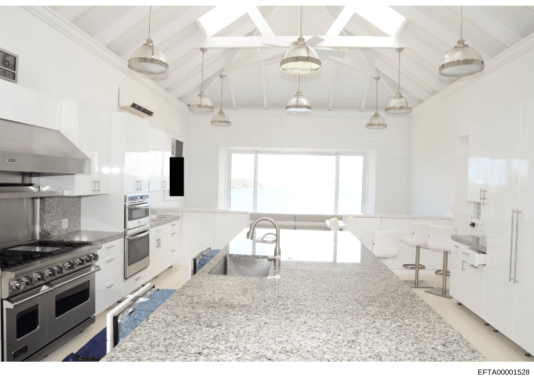 This is a photograph of a contemporary kitchen interior, likely part of property documentation or evidence from the investigation. The image shows a professionally designed kitchen space with luxury finishes, stainless steel appliances, granite count