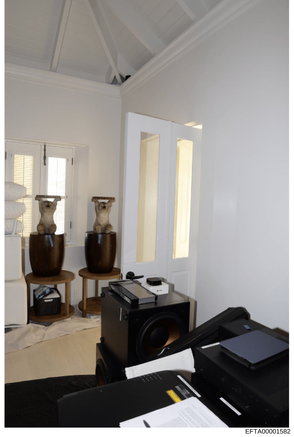 This photograph documents the interior of a bedroom, showing modern décor including two sculptural busts on wooden pedestals, mirrored closet doors, and contemporary furniture. The image appears to be evidence documentation from the investigation, ca