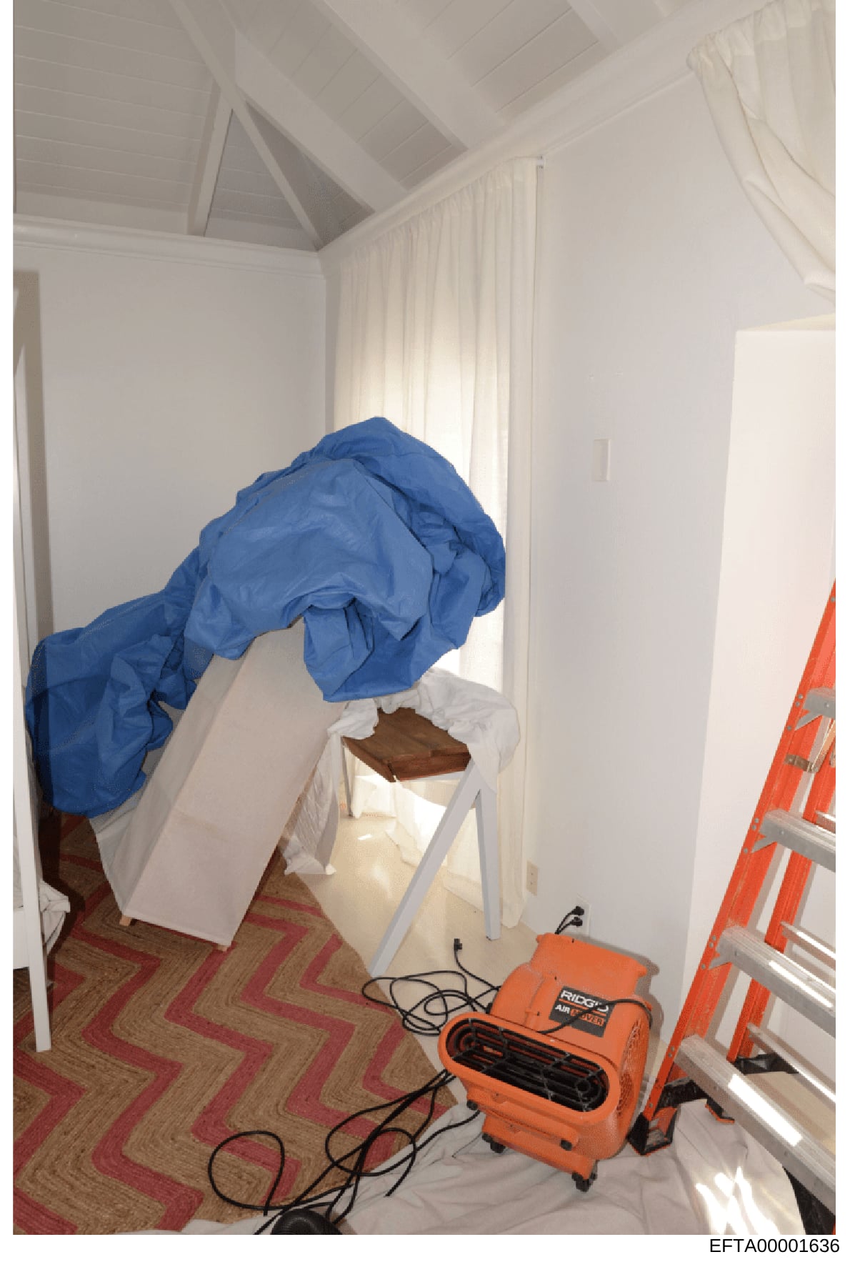 This is an evidence photograph showing the interior of a residential room undergoing remediation, renovation, or forensic investigation work. The room contains containment materials (blue plastic sheeting), white protective coverings, an orange RIDGI