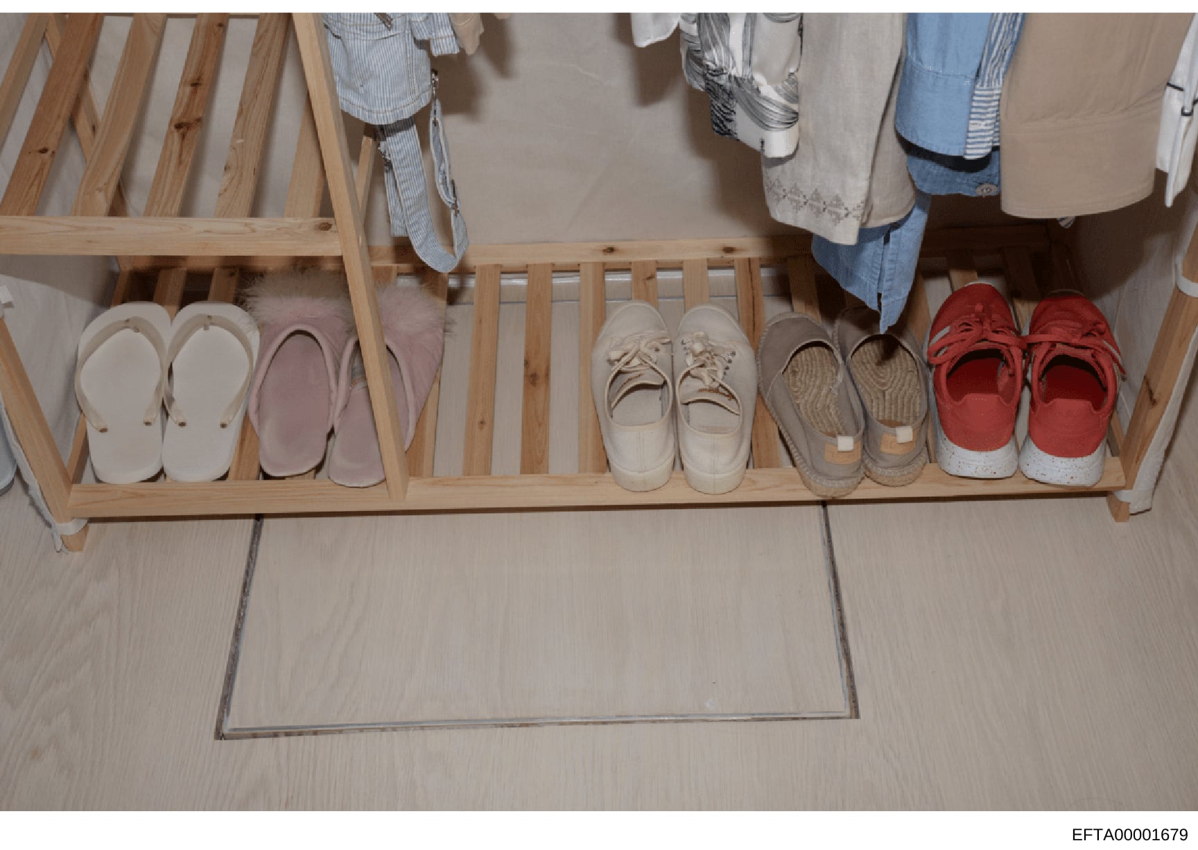 This is an evidence photograph showing the interior of a closet or entryway space containing a wooden shoe rack with multiple pairs of shoes in various styles and colors, along with hanging clothing visible above. The image documents the living space