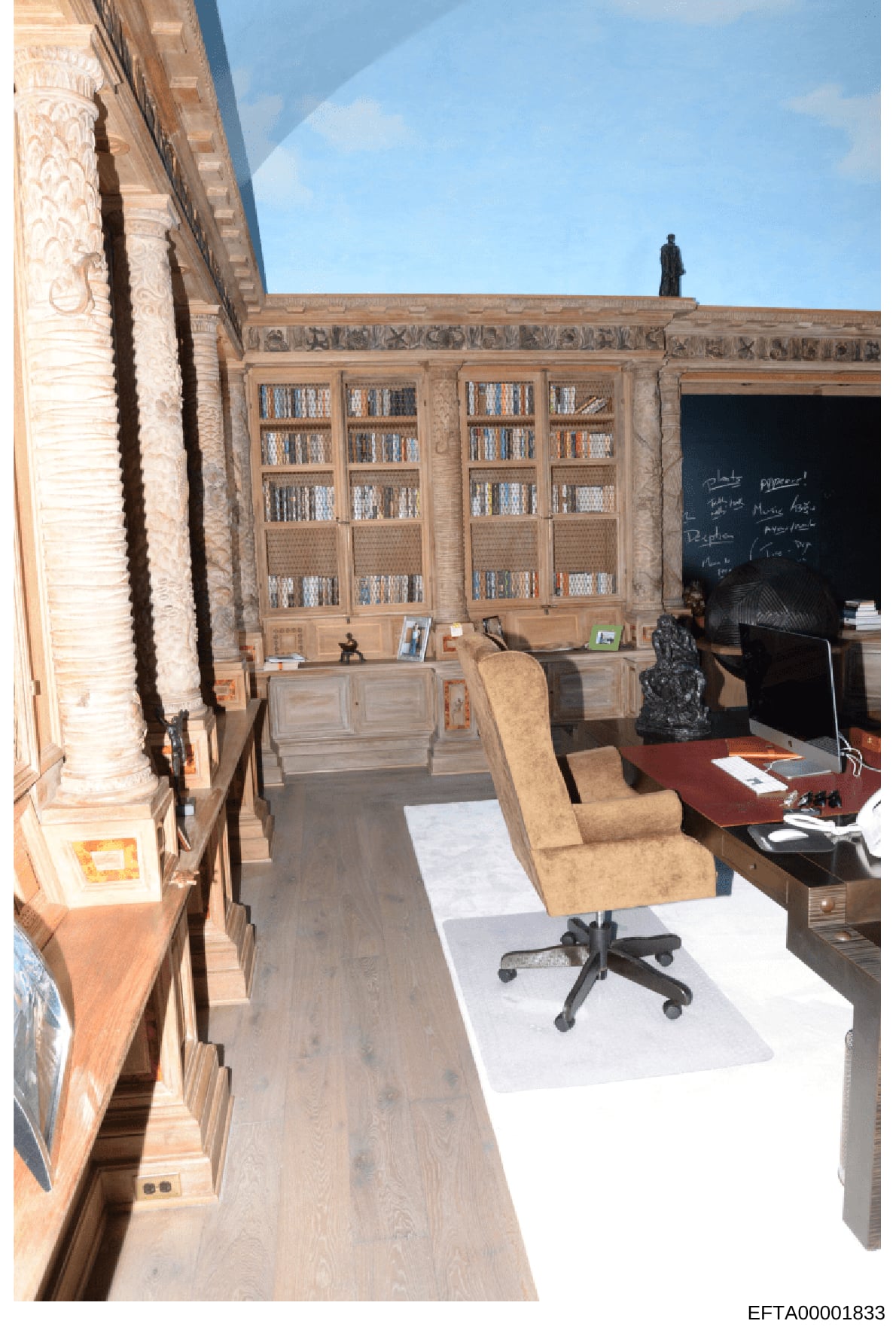 This is an evidence photograph showing an interior office or study space with ornate built-in wooden bookshelves, a desk with office equipment, and furniture. The room features decorative architectural elements and appears to be from a residential pr