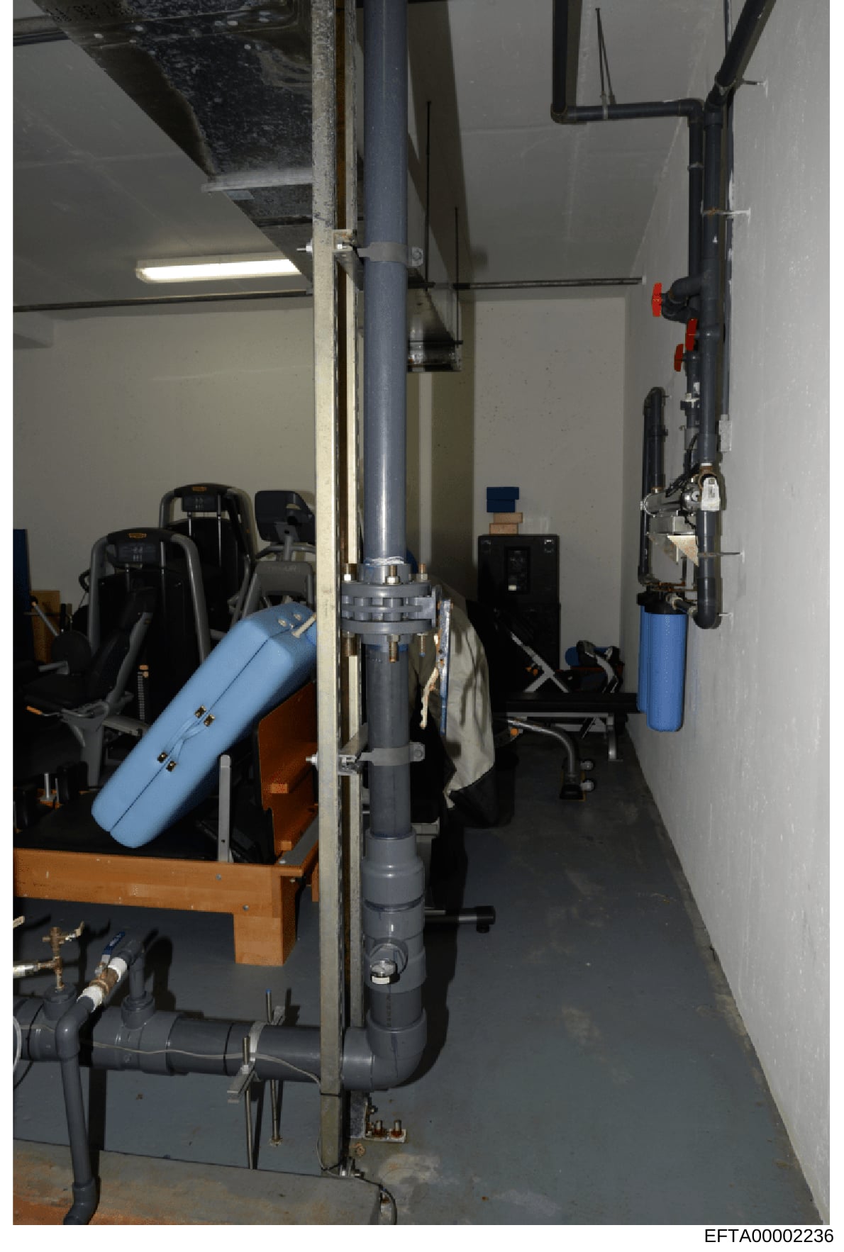 This photograph depicts the interior of a mechanical or utility room, showing HVAC equipment, water filtration systems, and various mechanical components. The image documents what appears to be building infrastructure, potentially from one of Epstein
