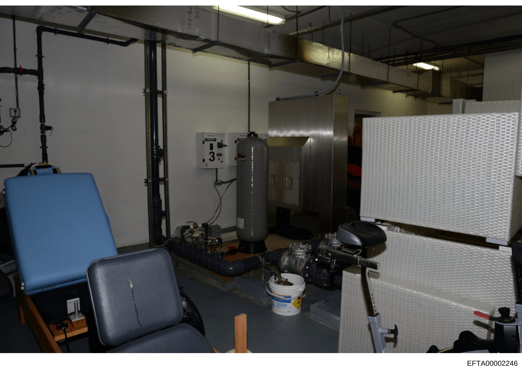 This is an evidence photograph showing an interior room or workspace containing various industrial and laboratory equipment. The space appears to be a utility or technical area with HVAC systems, metal storage units, electrical panels, and miscellane