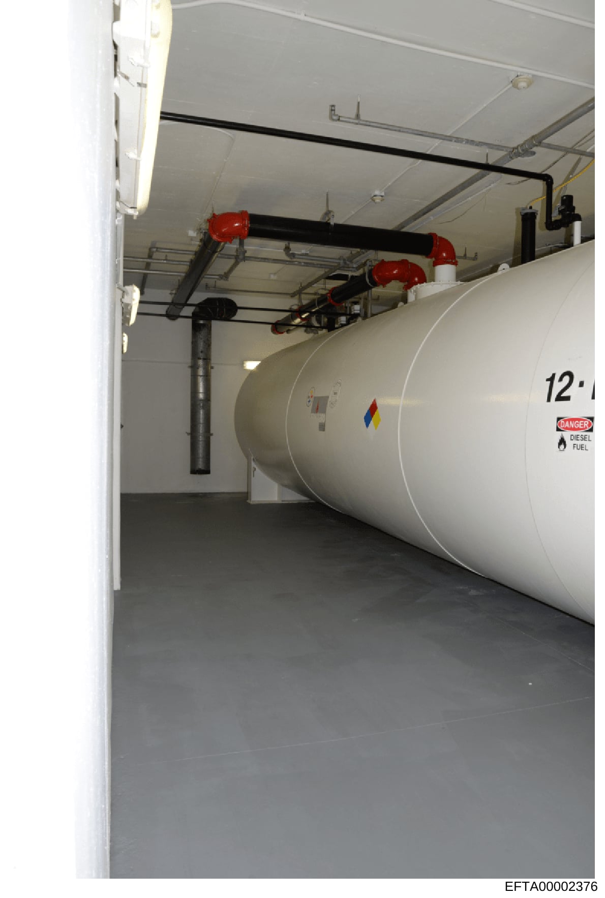 This is an evidence photograph showing the interior of a fuel storage room containing a large horizontal diesel fuel tank (labeled 12') with safety infrastructure including red shut-off valves, piping, and a 'Danger: Diesel Fuel' warning label. The i